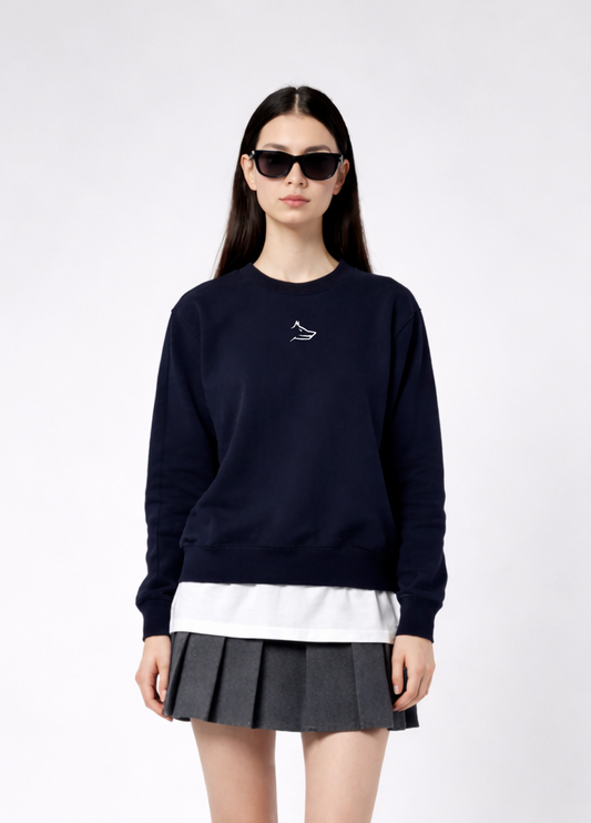 a woman wearing a french navy Northwind Lone wolf sweatshirt with Northwind embroidered wolf logo on the chest, white Northwind t-shirt under, pleated skirt, on a white background