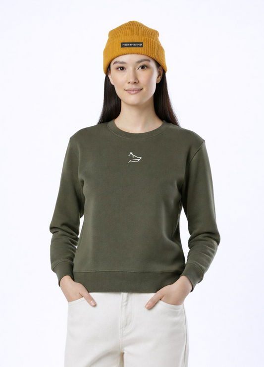 A woman wearing a khaki green Northwind Lone wolf sweatshirt with Northwind wolf embroidered logo on the chest, Northwind organic mustard beanie