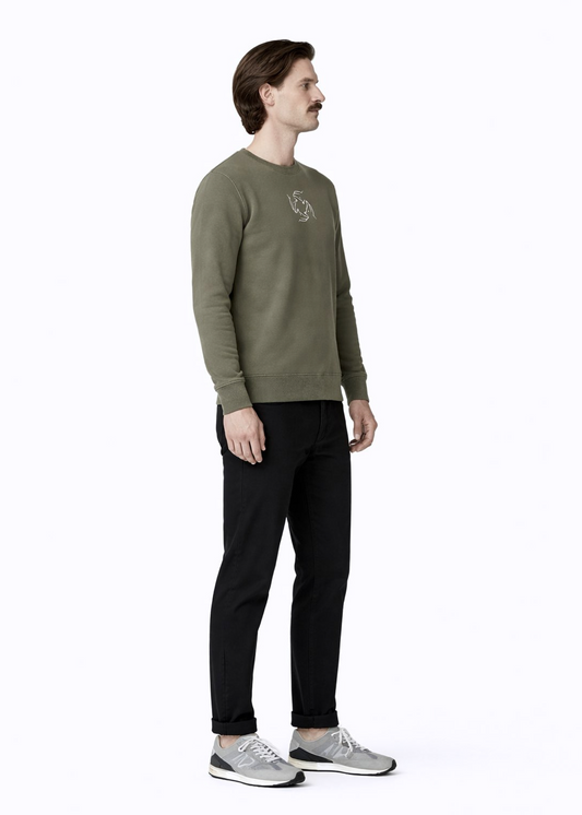 Man wearing a khaki green Northwind sweatshirt with white embroidered storm of wolves logo of Northwind on the chest, grey new balance shoes