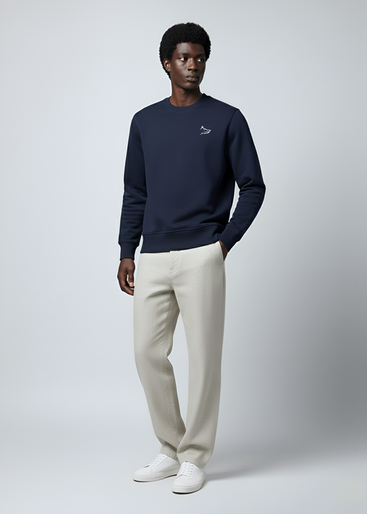 Man wearing a Northwind crossword wolf navy sweatshirt and beige pants on a white background