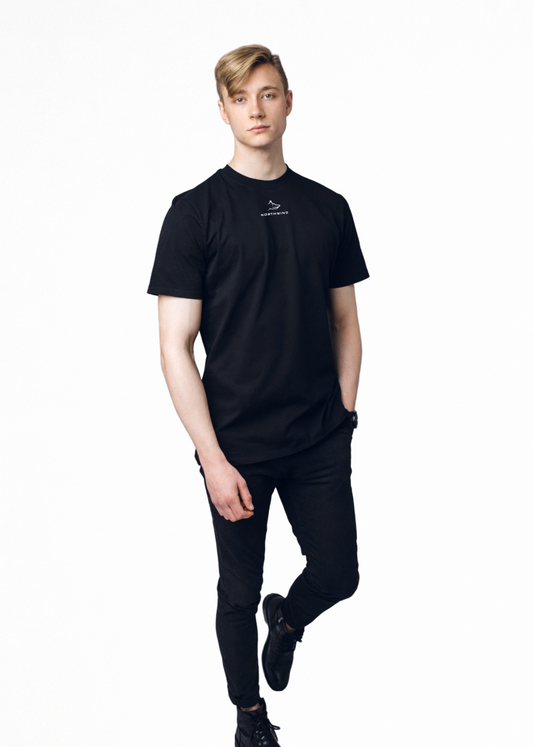 Blond man wearing a black Northwind casual t-shirt with minimalist Northwind embroidered wolf logo on the chest, black Casio watch