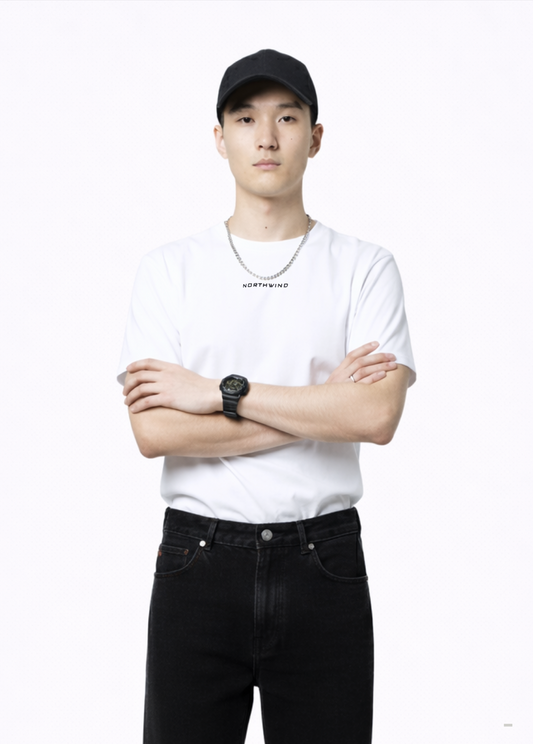 Man wearing an essential Northwind white t-shirt with minimalist Northwind embroidered wolf logo on the back, Black Rolex watch, Carhartt black pants