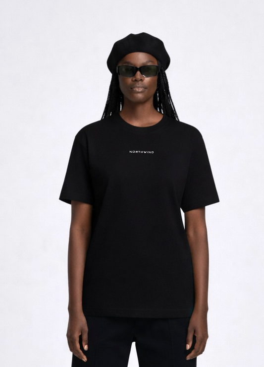 Black woman wearing a black essential Northwind t-shirt with embroidered logo on the chest, Gucci sunglasses and black beret.
