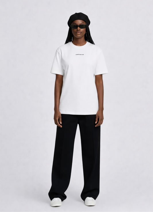 Black woman wearing a white essential Northwind t-shirt with embroidered logo, Gucci sunglasses, black beret and black pants
