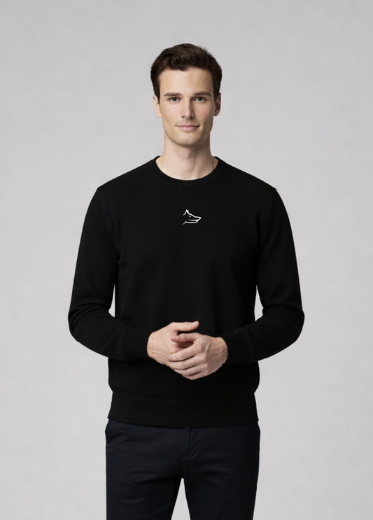 Man wearing a black Northwind sweater with white embroidered Northwind wolf logo on the chest