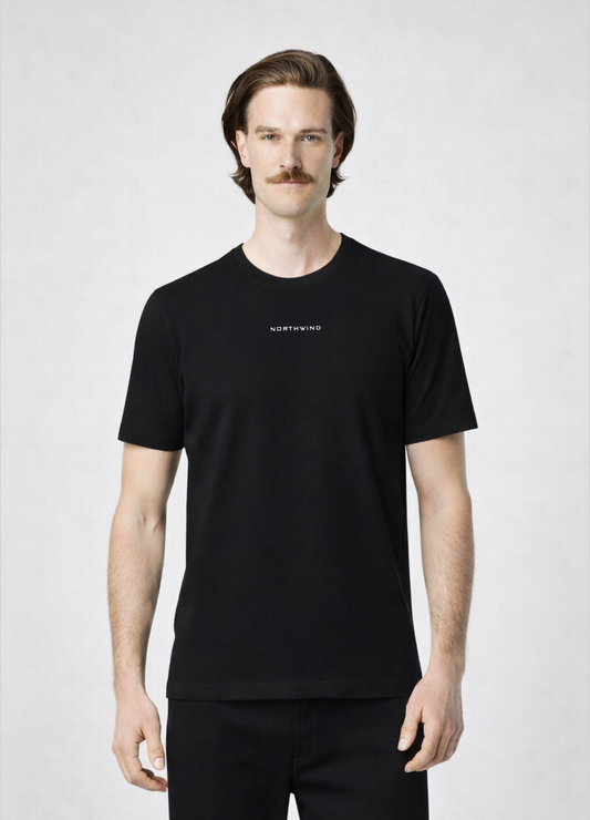 Man wearing a black Northwind storm of wolves t-shirt with embroidered Northwind logo on the chest