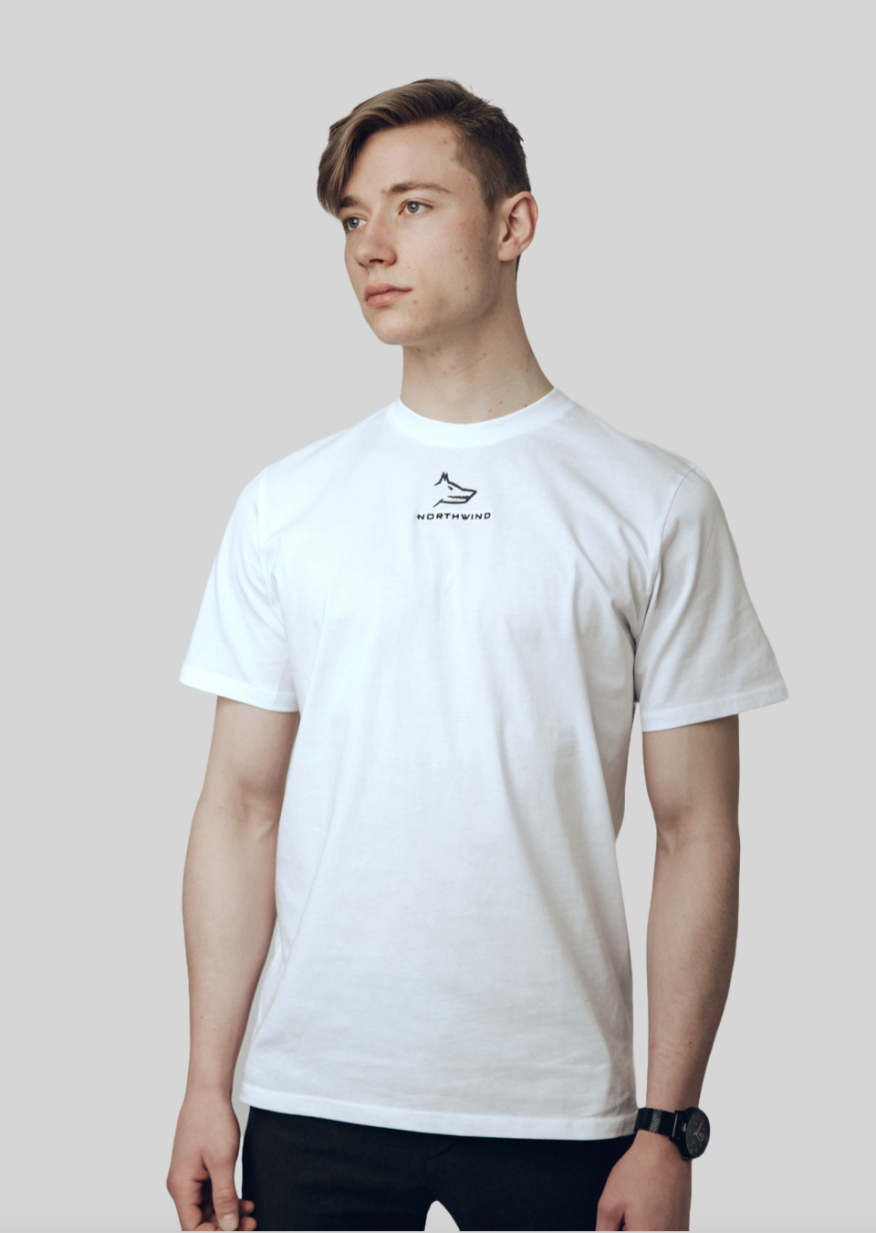 Person wearing a Northwind white t-shirt with a wolf logo on a plain background