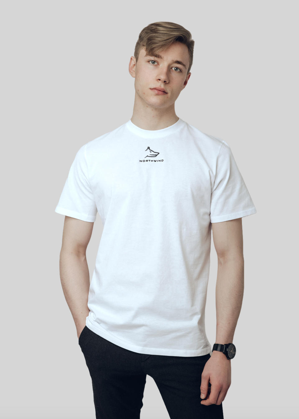 Person wearing a white casual Northwind t-shirt with a wolf logo on a plain background