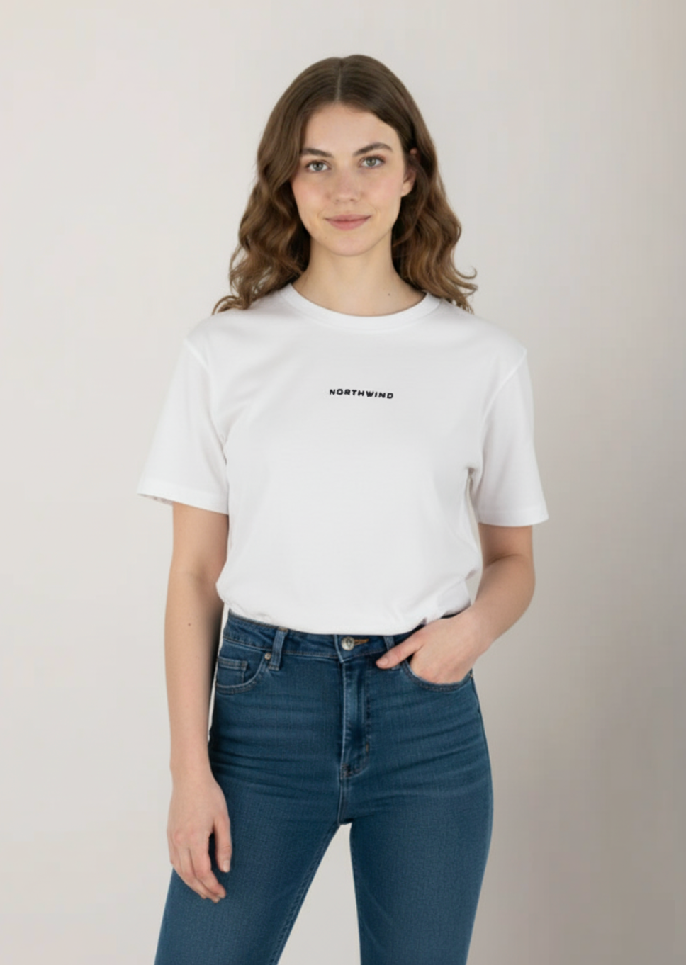 a model wearing a Essential White T-shirt with Northwind Logo Embroidery and blue jeans on a plain background