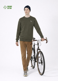 Man wearing a khaki green organic cotton Northwind sweatshirt with white embroidered Northwind wolf logo on the chest, having bike