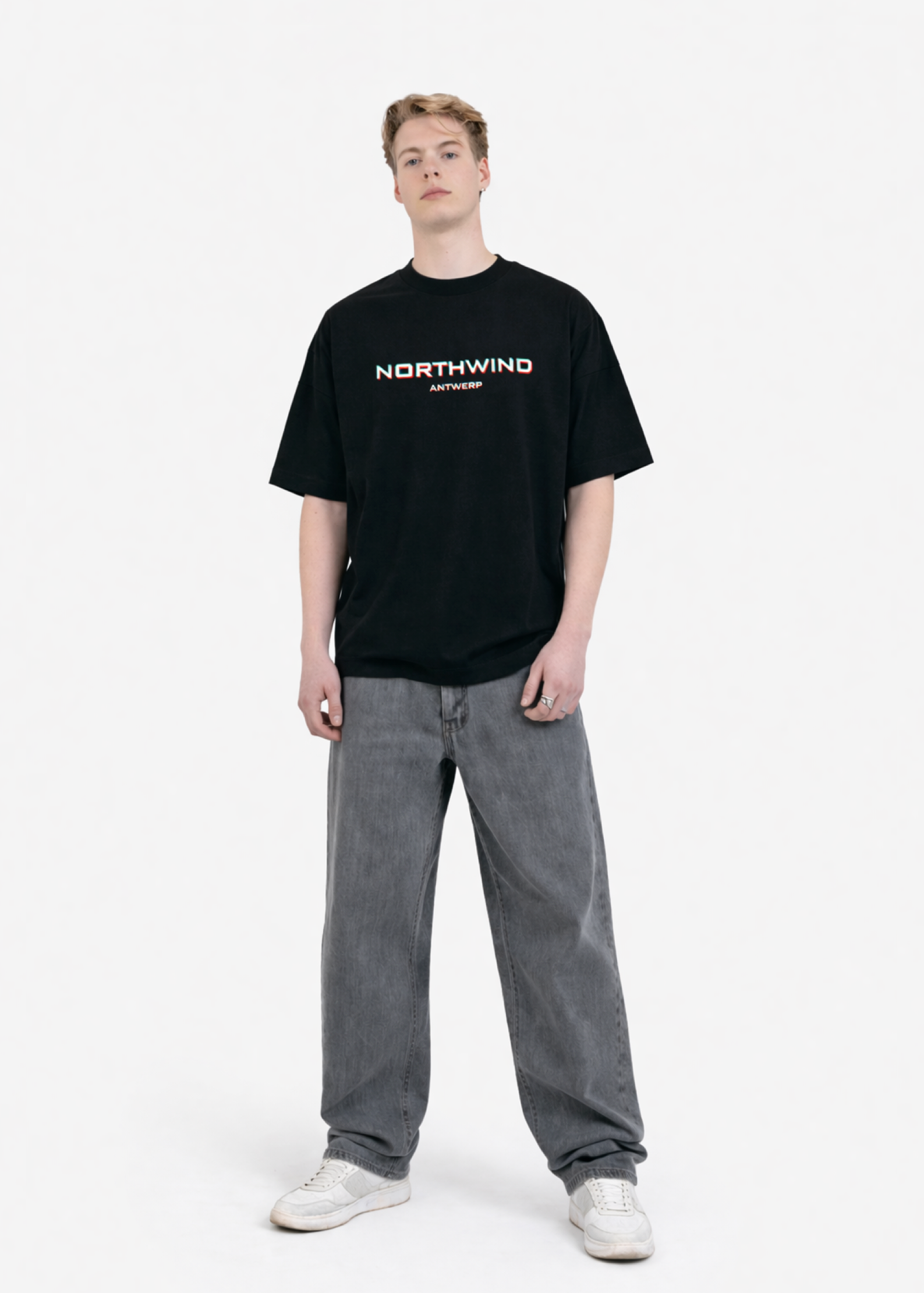 Person wearing a black 'NORTHWIND' t-shirt with Glitch design on the chest and gray jeans