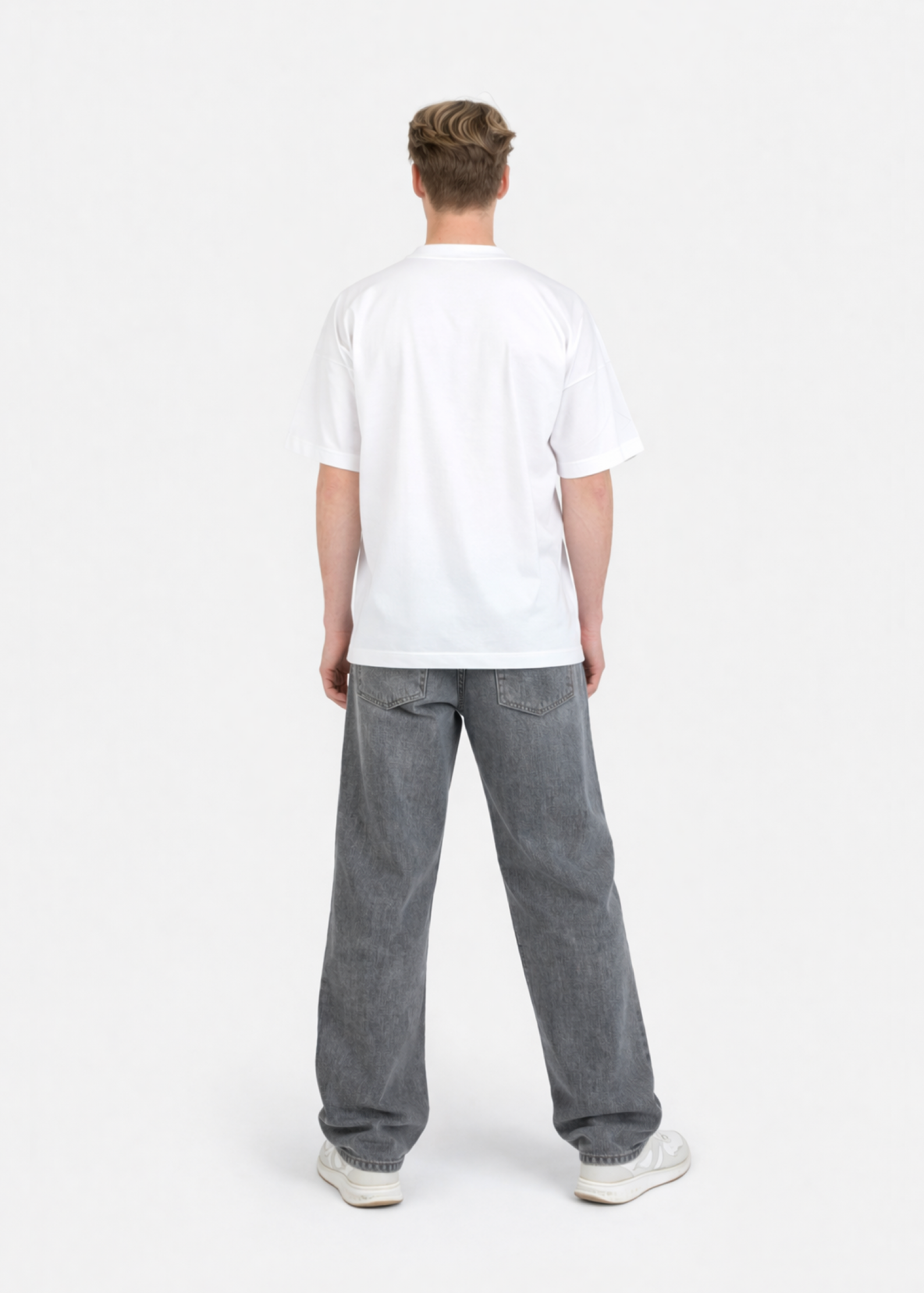 Person wearing a white organic cotton oversized Northwind t-shirt and gray jeans on a white background