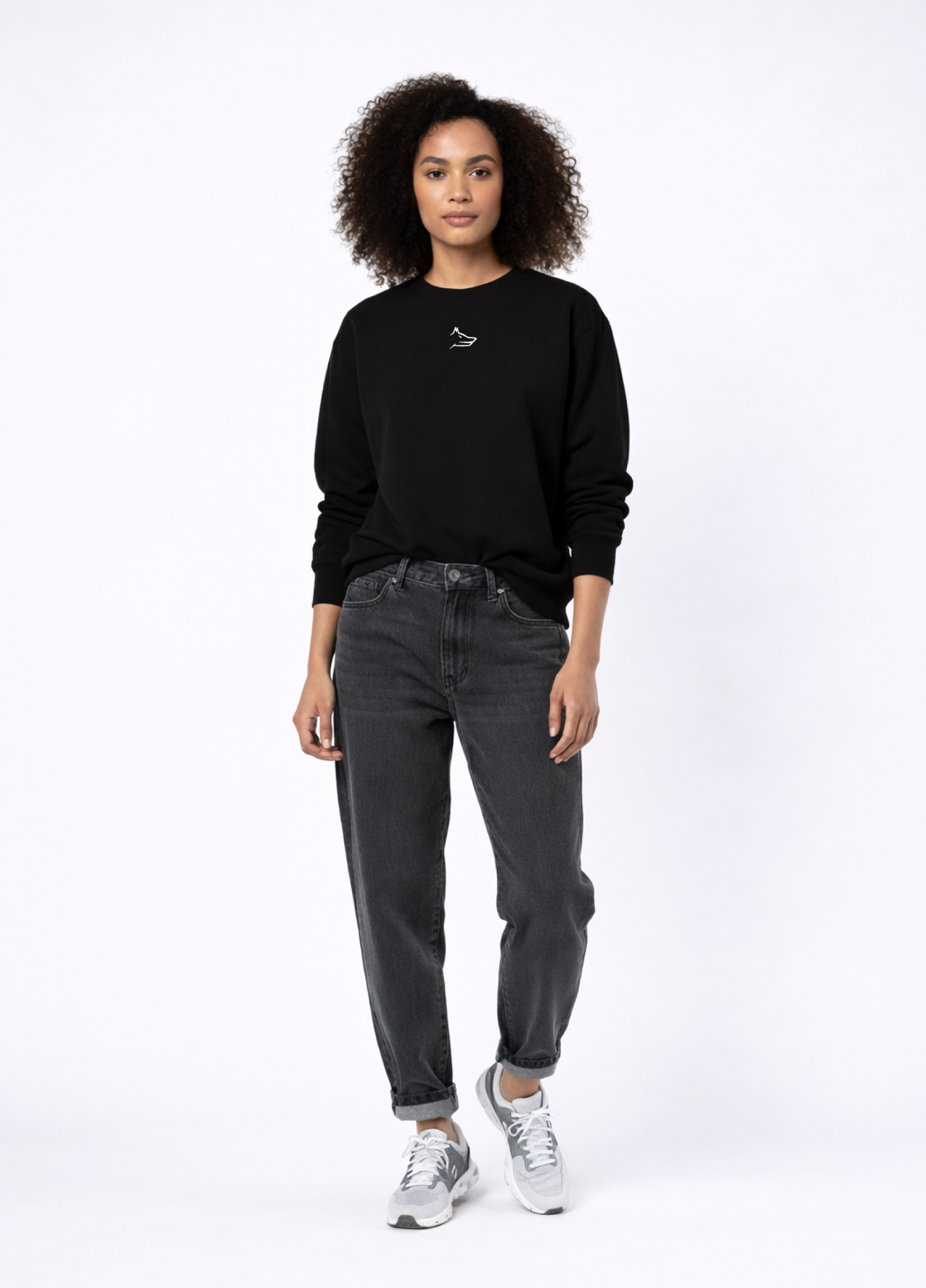Woman wearing Northwind Lone Wolf black sweatshirt with wolf logo embroidered on the chest, gray levis jeans and New Balance shoes