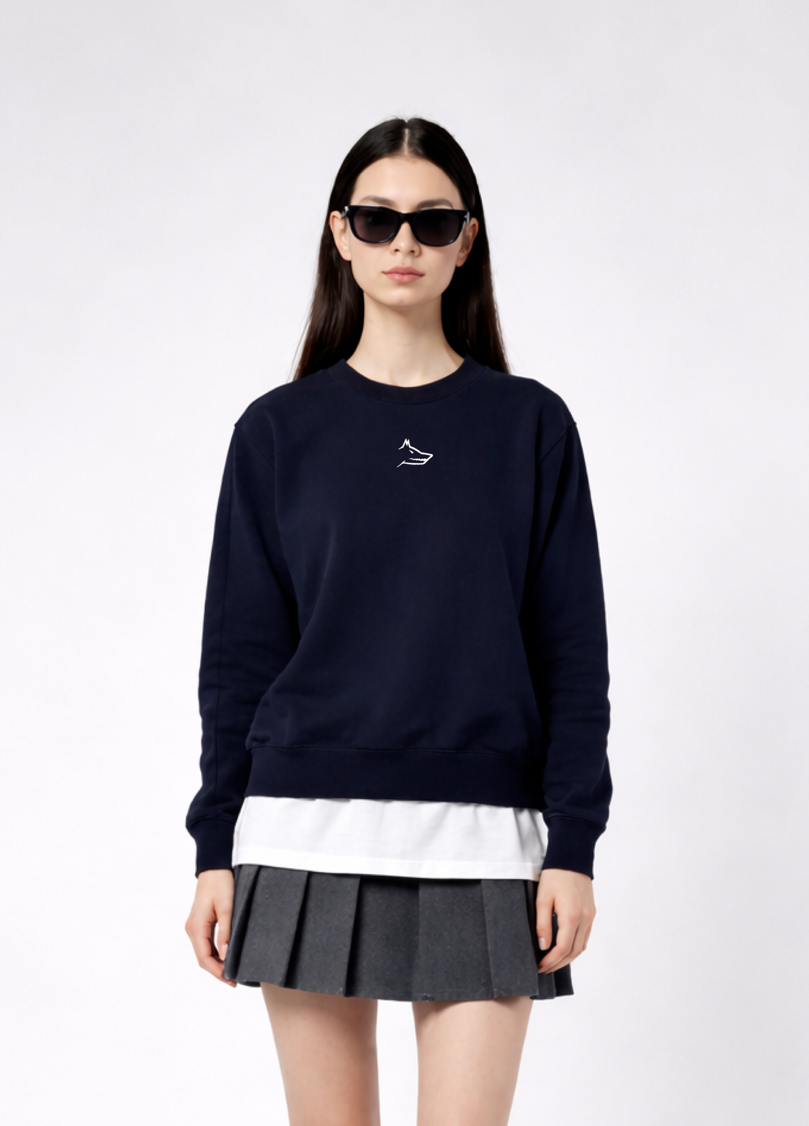 a woman wearing a french navy Northwind Lone wolf sweatshirt with Northwind embroidered wolf logo on the chest, white Northwind t-shirt under, pleated skirt, on a white background
