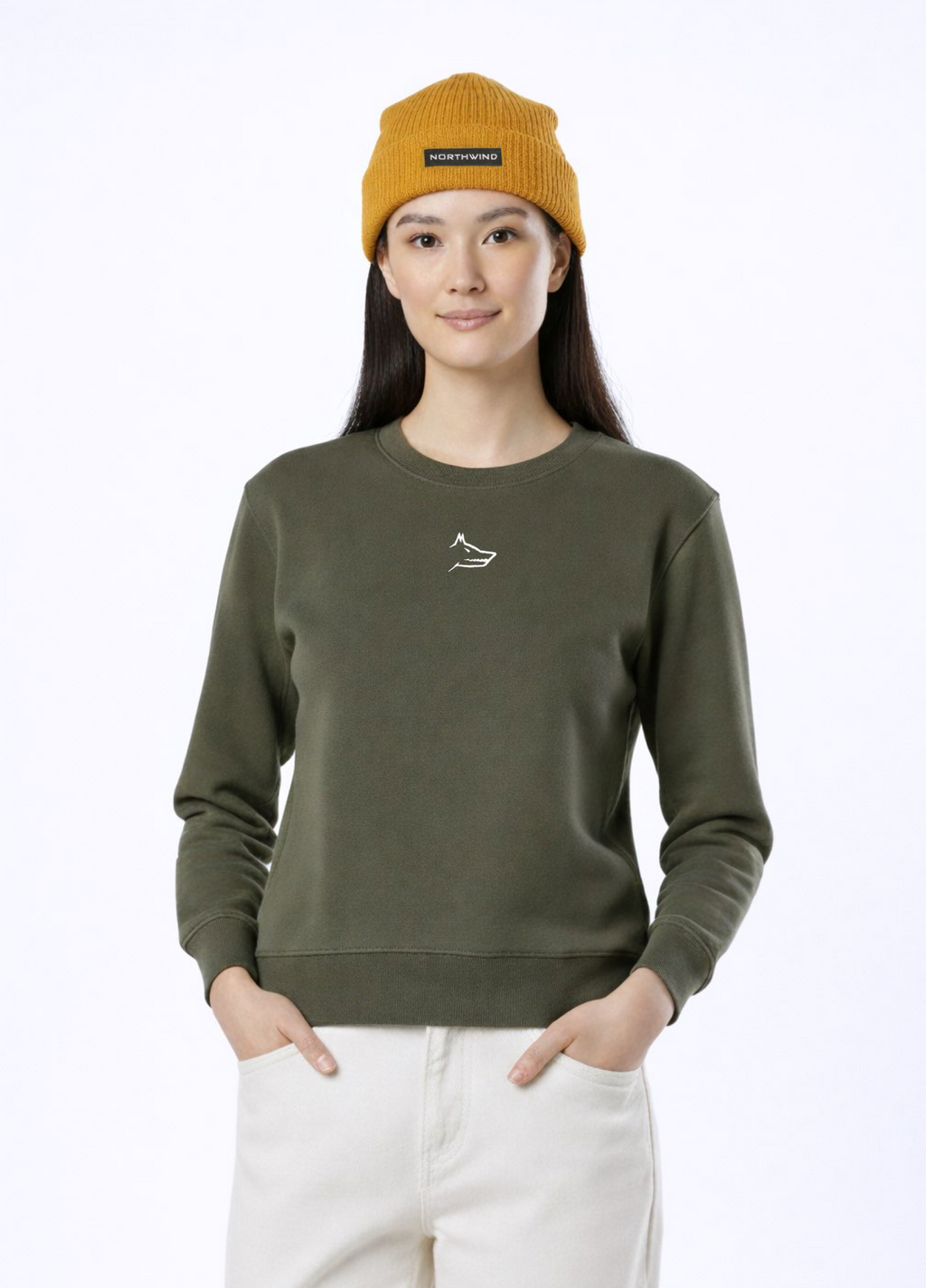 A woman wearing a khaki green Northwind Lone wolf sweatshirt with Northwind wolf embroidered logo on the chest, Northwind organic mustard beanie 