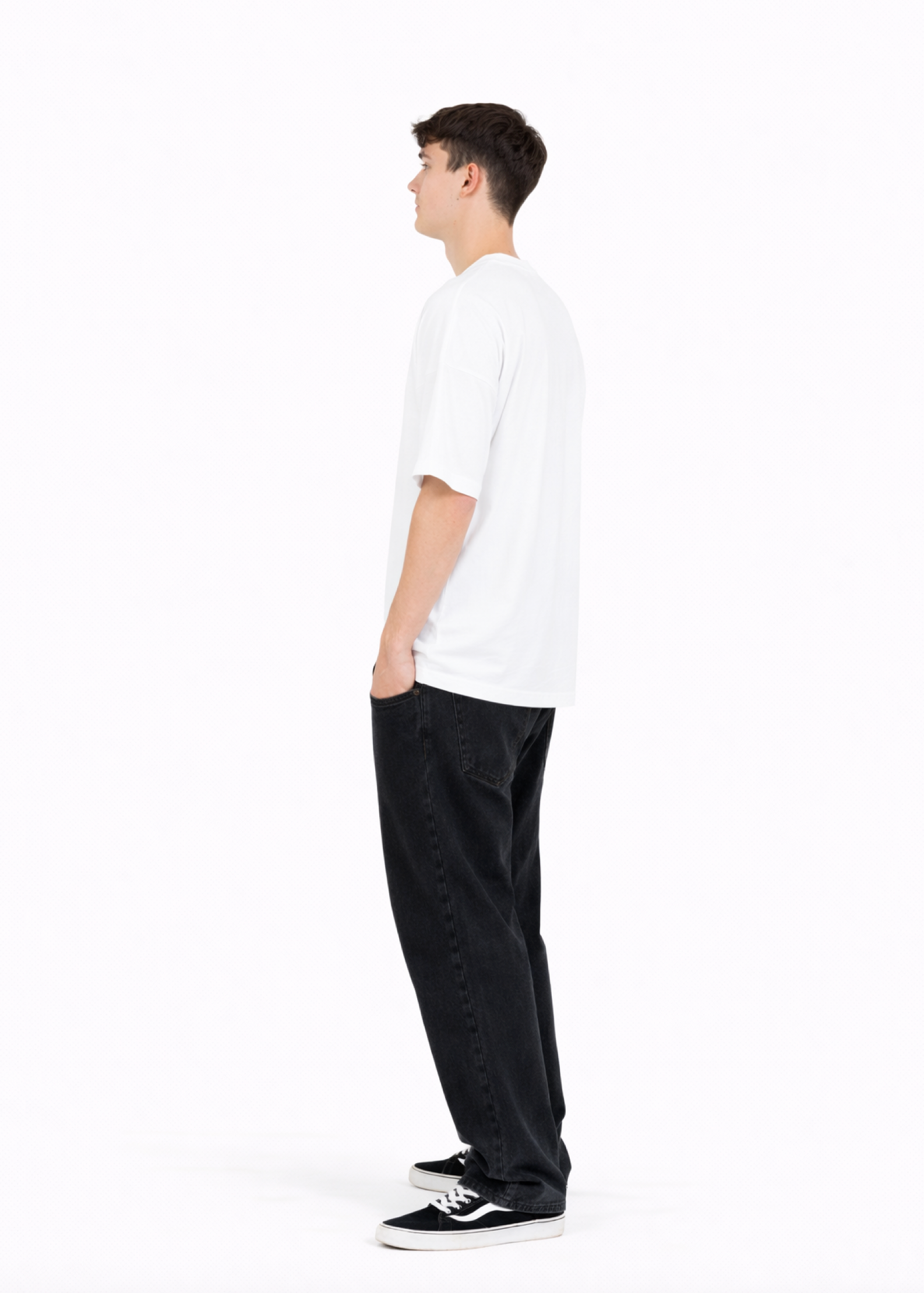 Young adult wearing a Northwind oversized organic cotton white t-shirt with embroidery on the chest, Carhartt pants, black Vans shoes