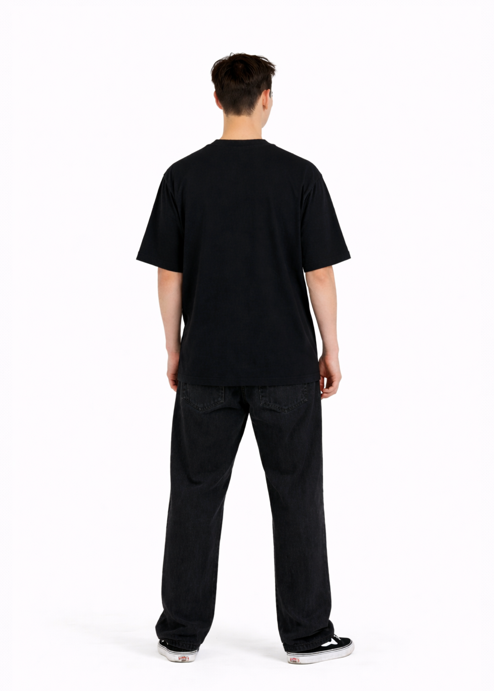 Young adult wearing a Northwind oversized organic cotton black t-shirt with Northwind embroideredy on the chest, Carhartt pants, black Vans shoes