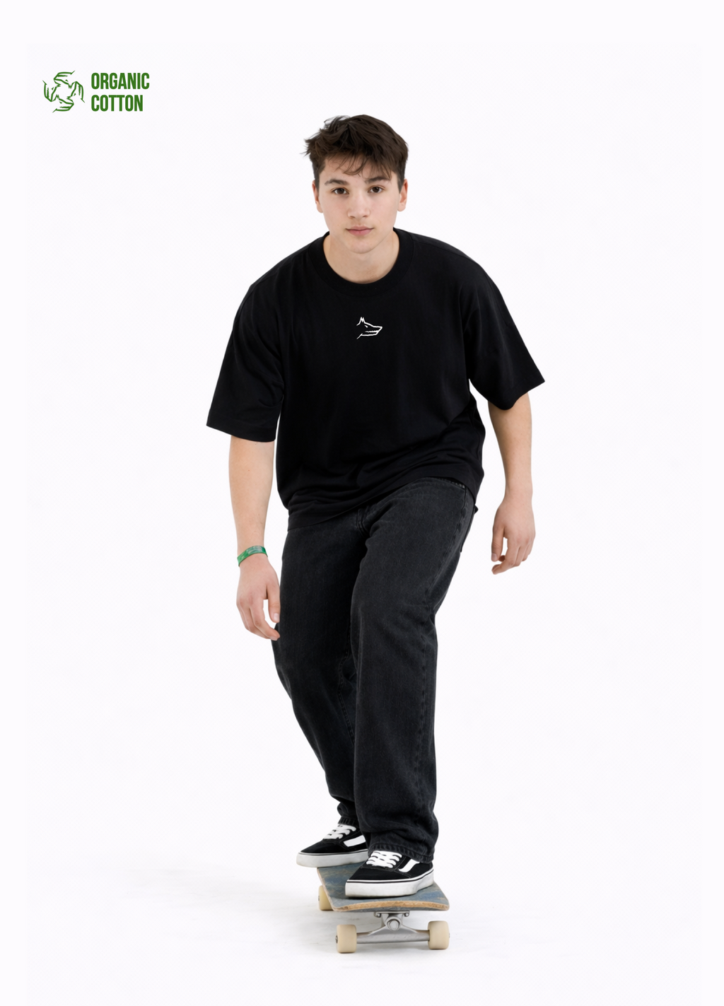 Young adult wearing a Northwind oversized organic cotton black t-shirt with Northwind wolf logo embroidered on the chest, Carhartt pants, black Vans shoes, skating