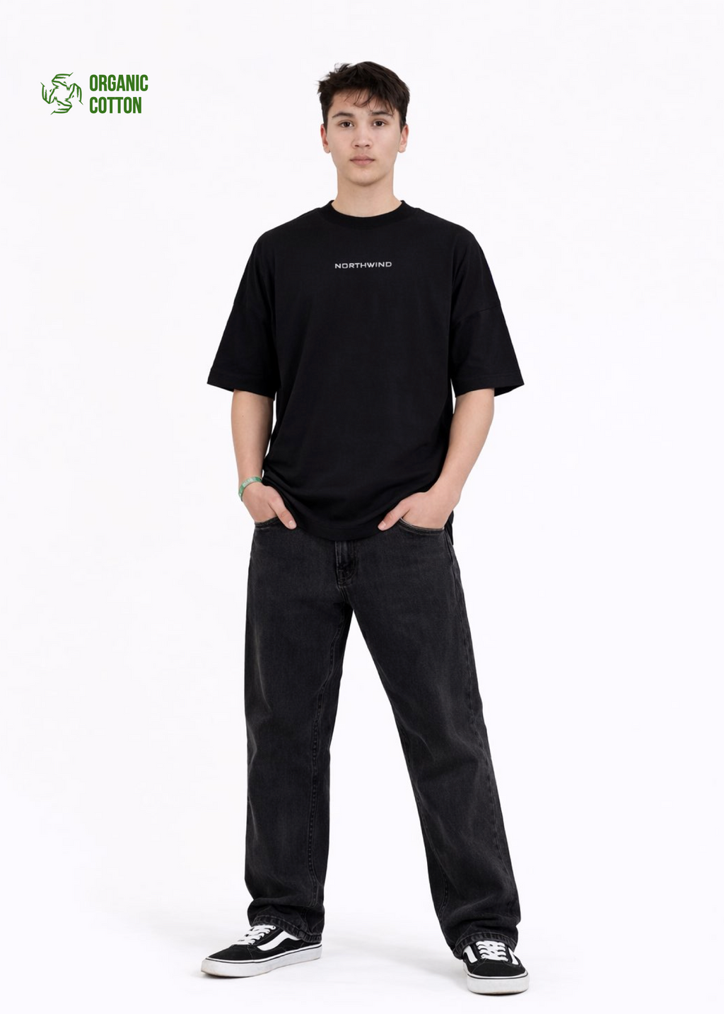 Young adult wearing a Northwind oversized organic cotton black t-shirt with Northwind embroidered on the chest, Carhartt pants, black Vans shoes