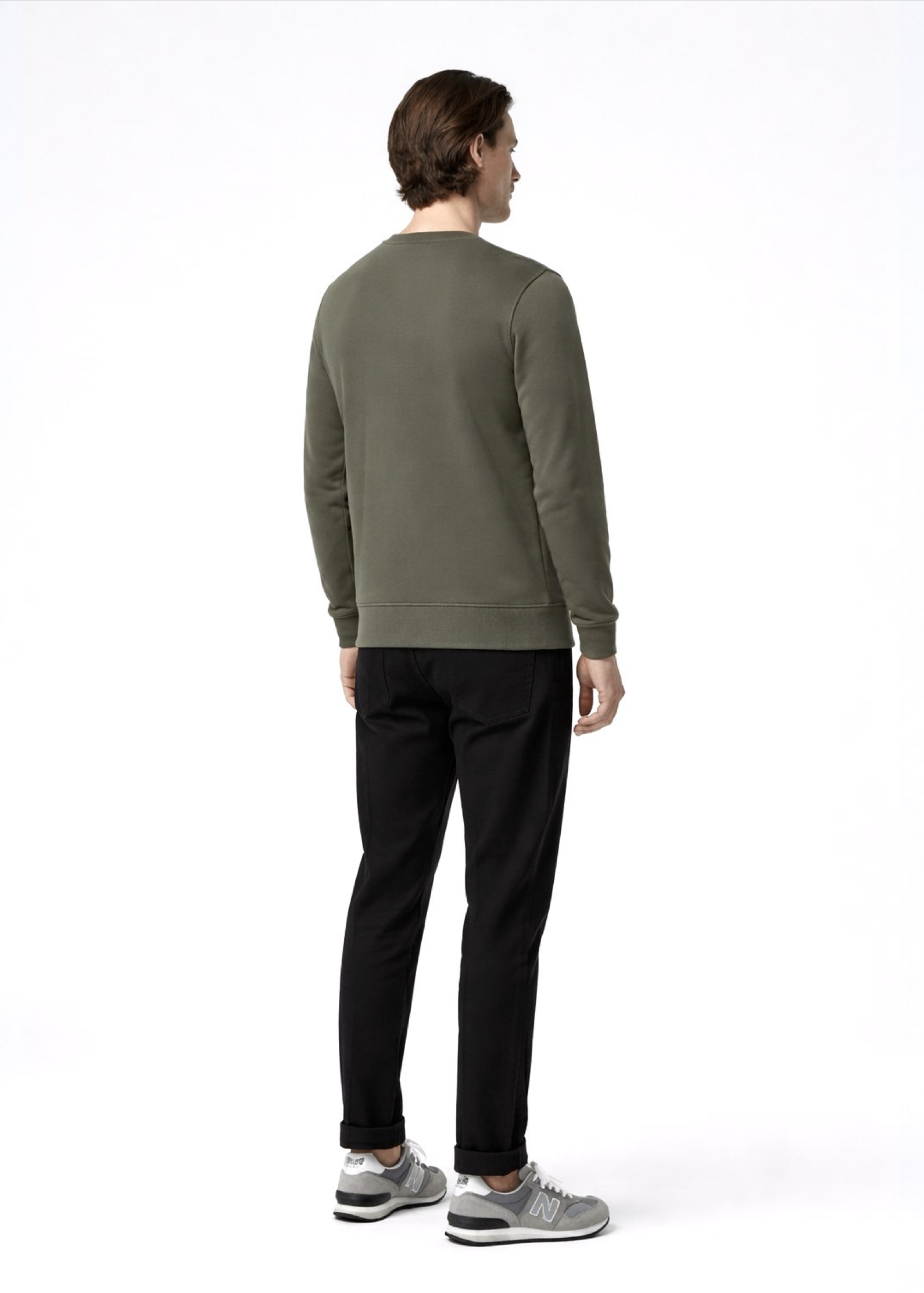 A man wearing a khaki green Northwind sweatshirt, new balance shoes