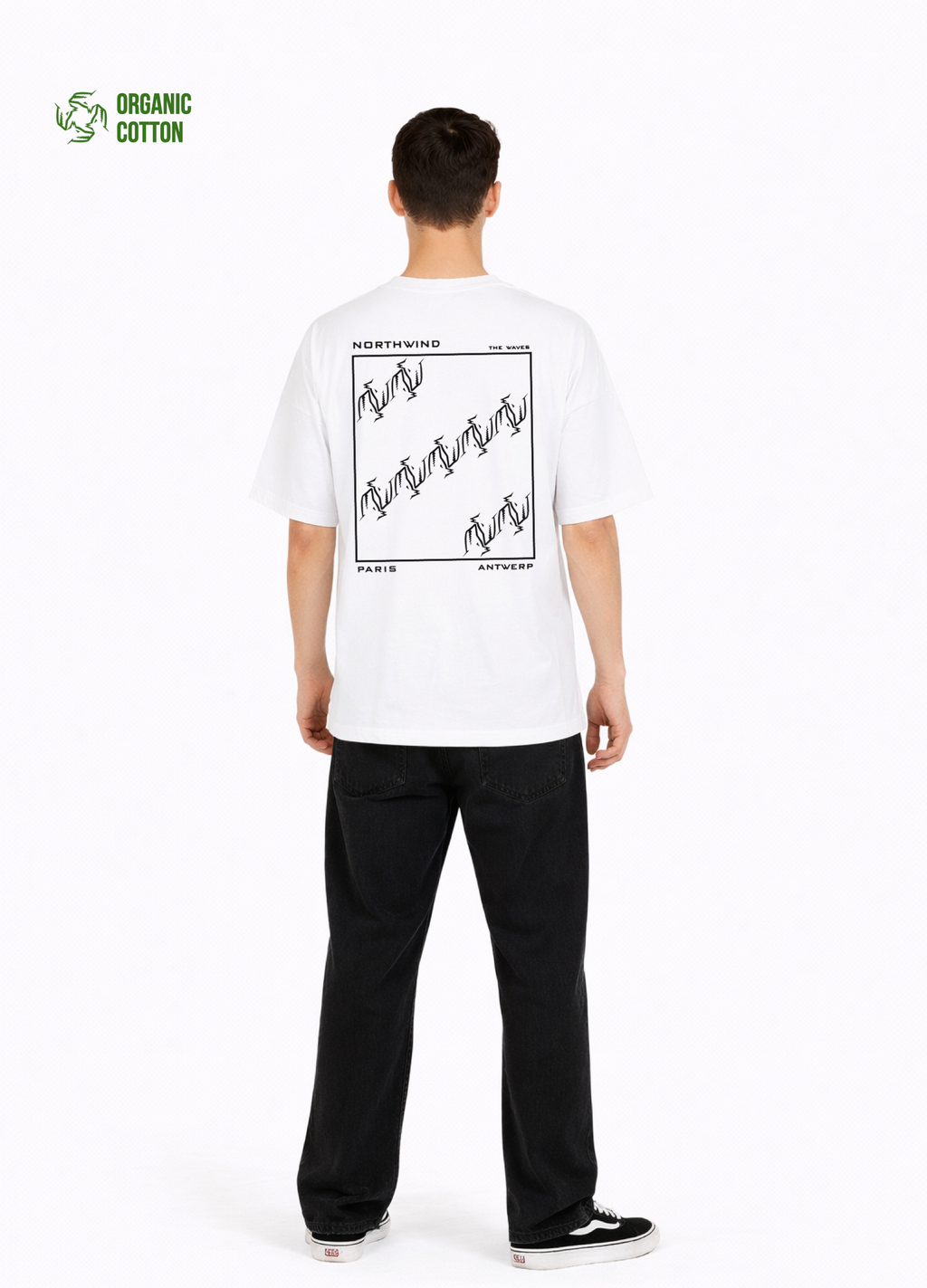 Young adult wearing a Northwind oversized organic cotton white t-shirt with Northwind embroidered on the chest, the waves design screen printed on the back, Carhartt pants, black Vans shoes