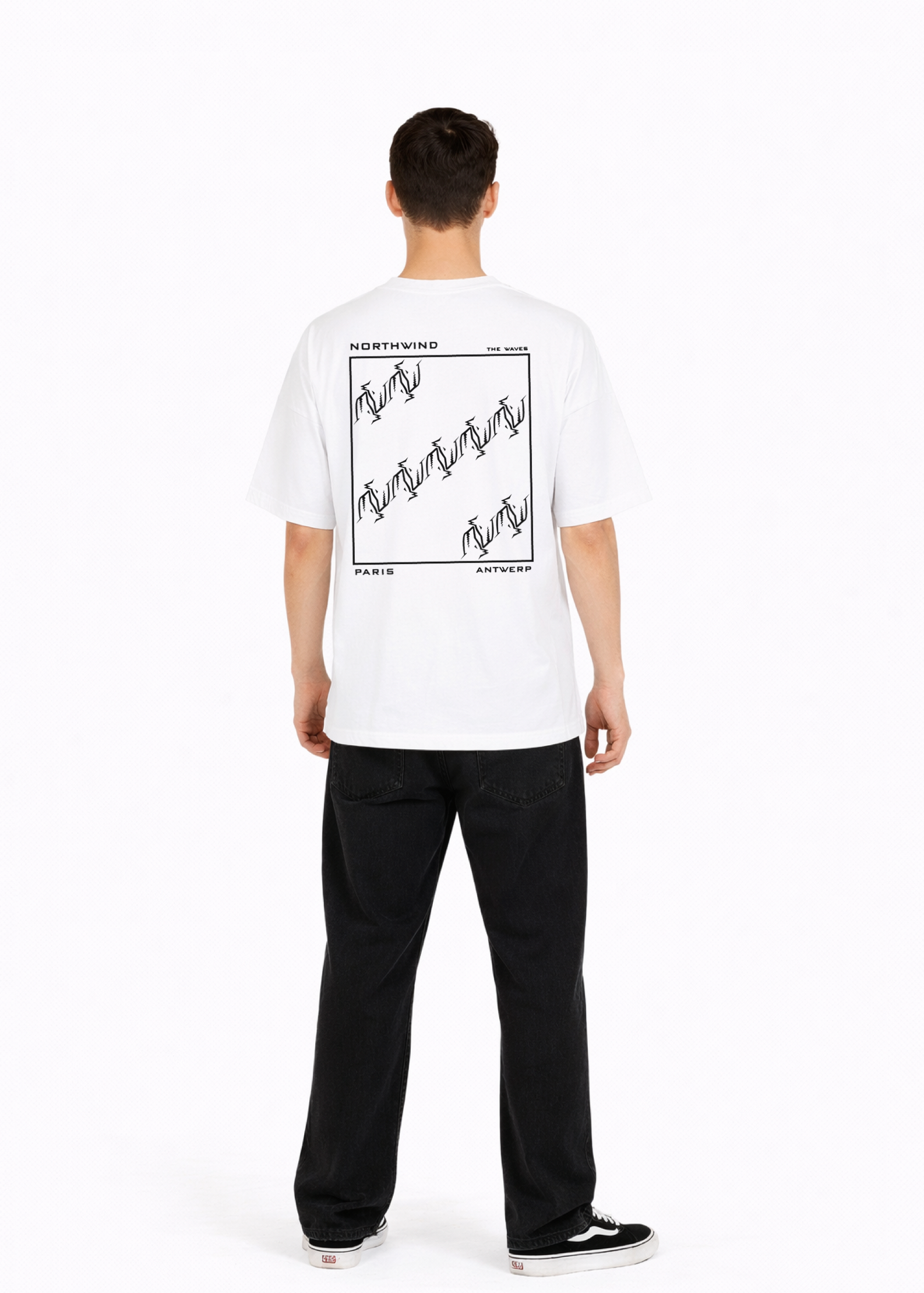 Young adult wearing a Northwind oversized organic cotton white t-shirt with Northwind embroidered on the chest, the waves design screen printed on the back, Carhartt pants, black Vans shoes