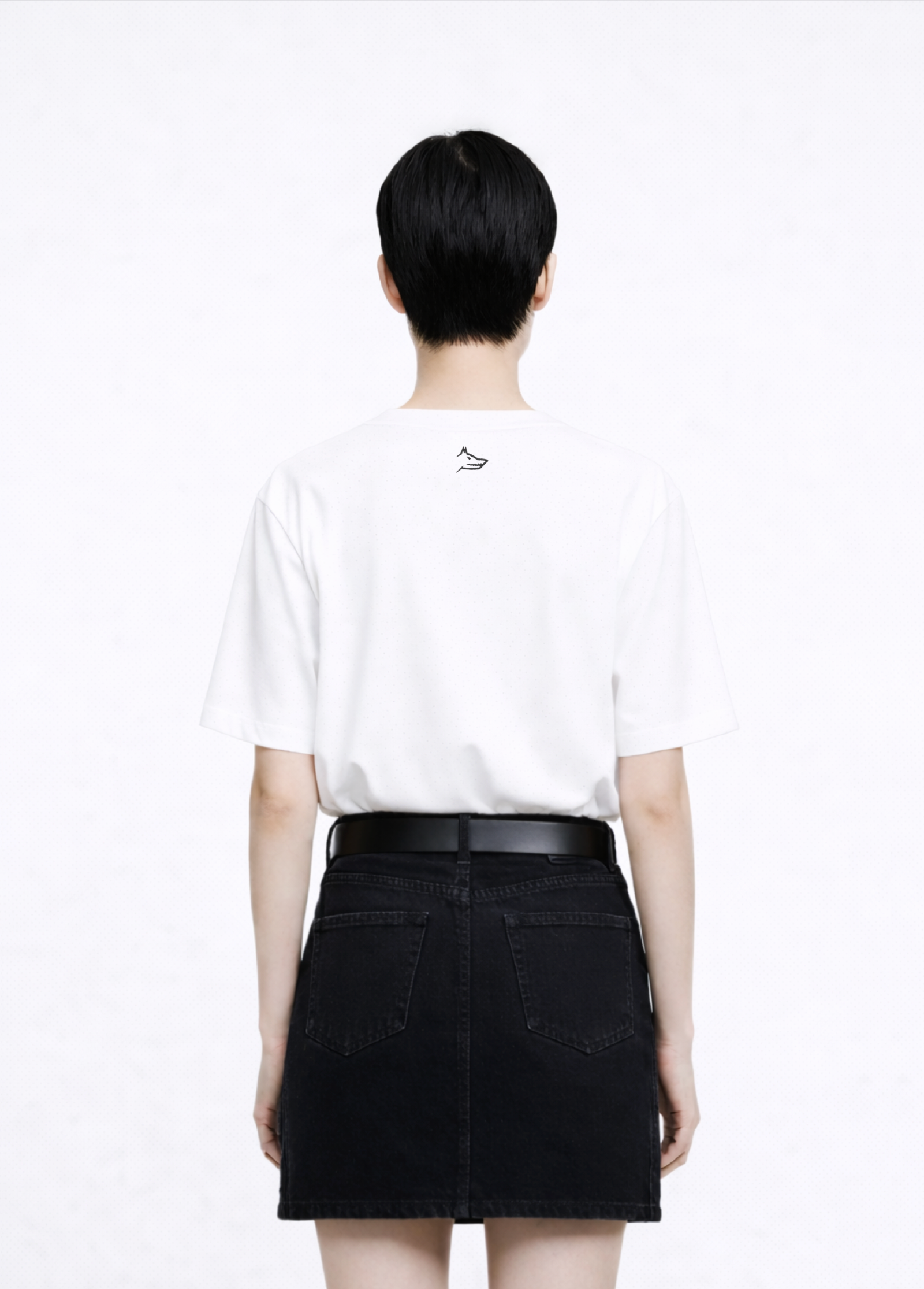 Woman wearing a white Northwind casual t-shirt with minimalist Northwind embroidered wolf logo at the back and black skirt on a white background