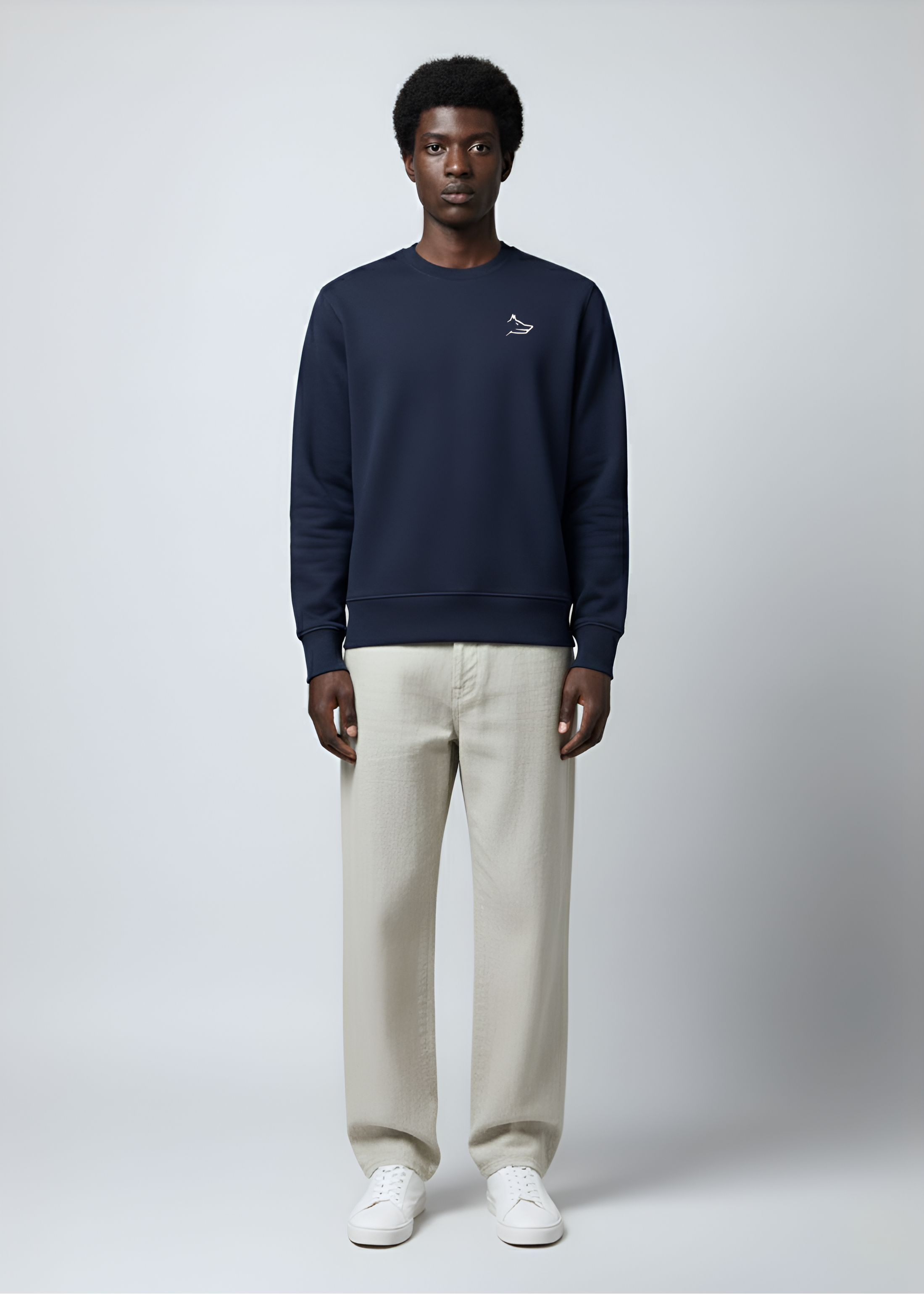 Man wearing a Northwind crossword wolf navy sweatshirt and beige pants on a white background, giving a front pose
