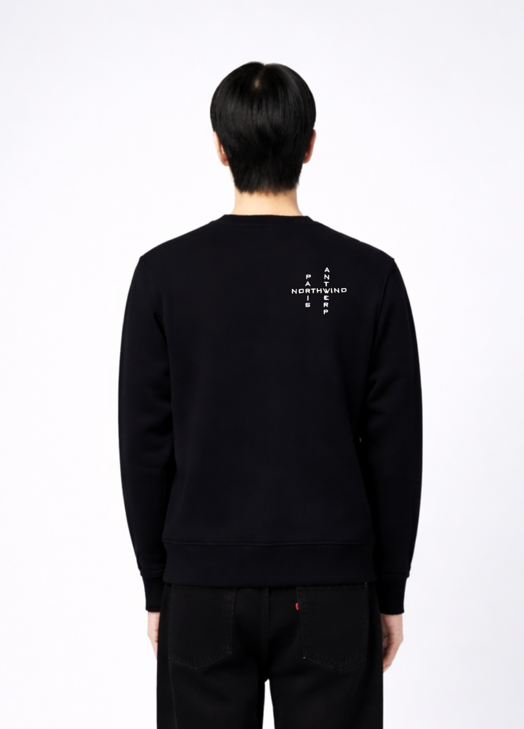 Person wearing a black Northwind sweatshirt with white crossword Paris Antwerp embroidered logo on the back, close back pose