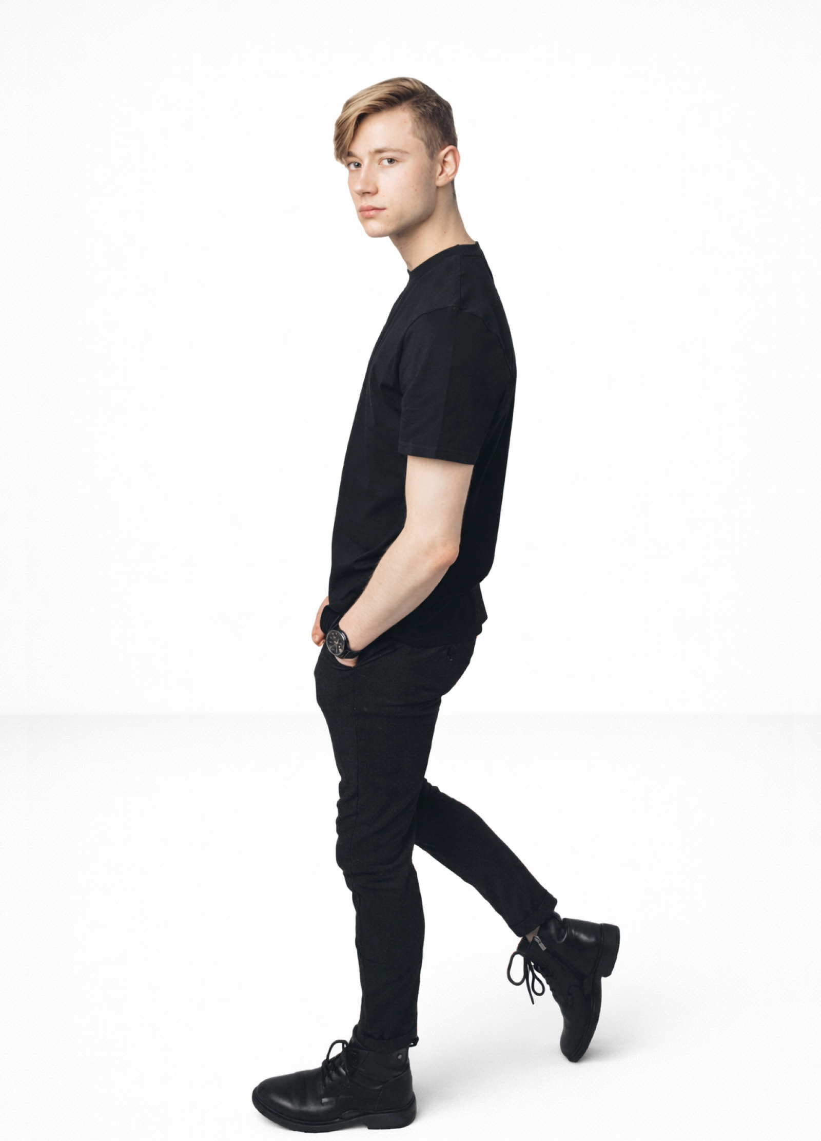 Blond man wearing a black Northwind casual t-shirt with minimalist Northwind embroidered wolf logo on the chest, black Casio watch and black boots