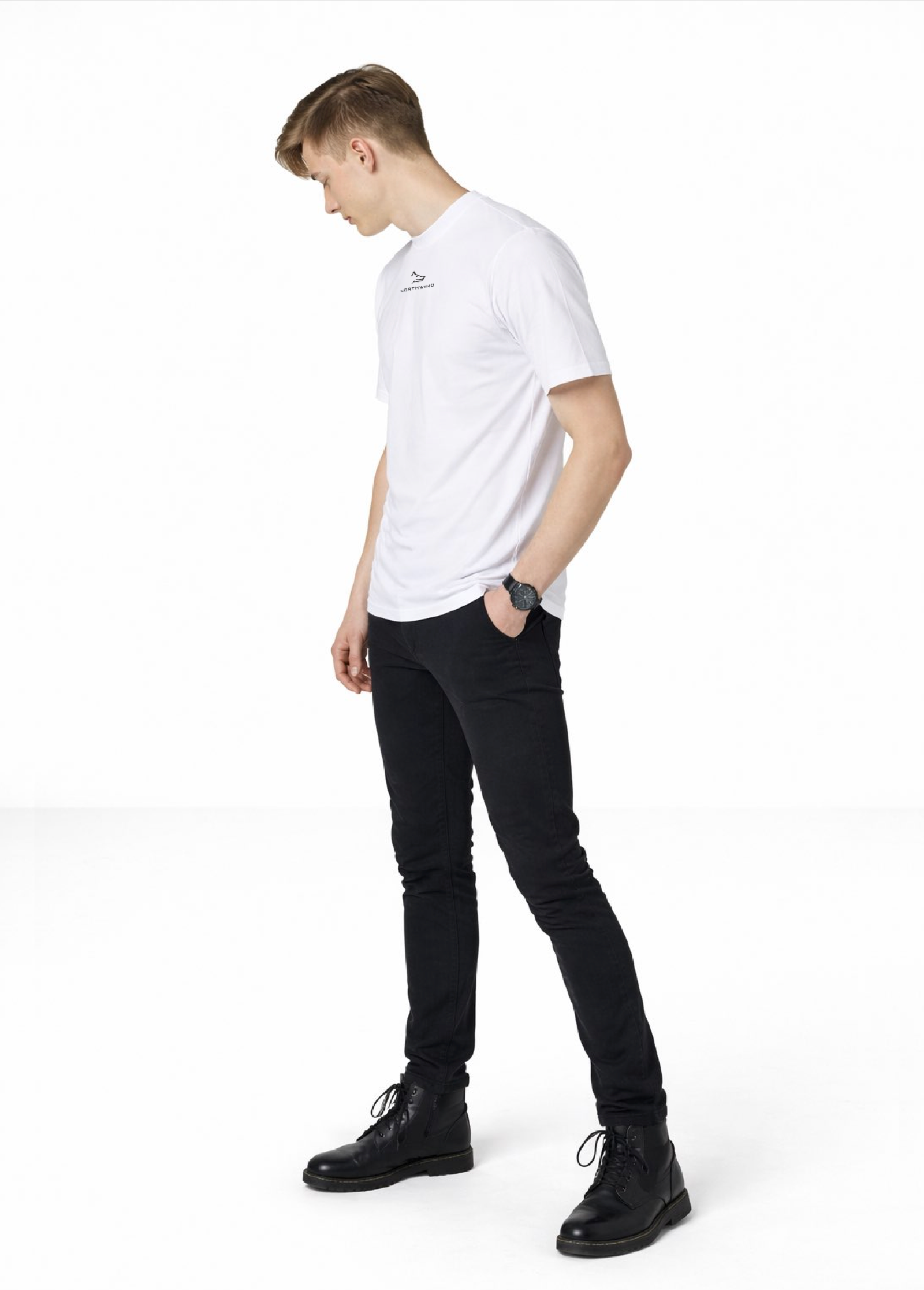 Blond man wearing a white Northwind casual t-shirt with minimalist Northwind embroidered wolf logo on the chest, black Casio watch and boots