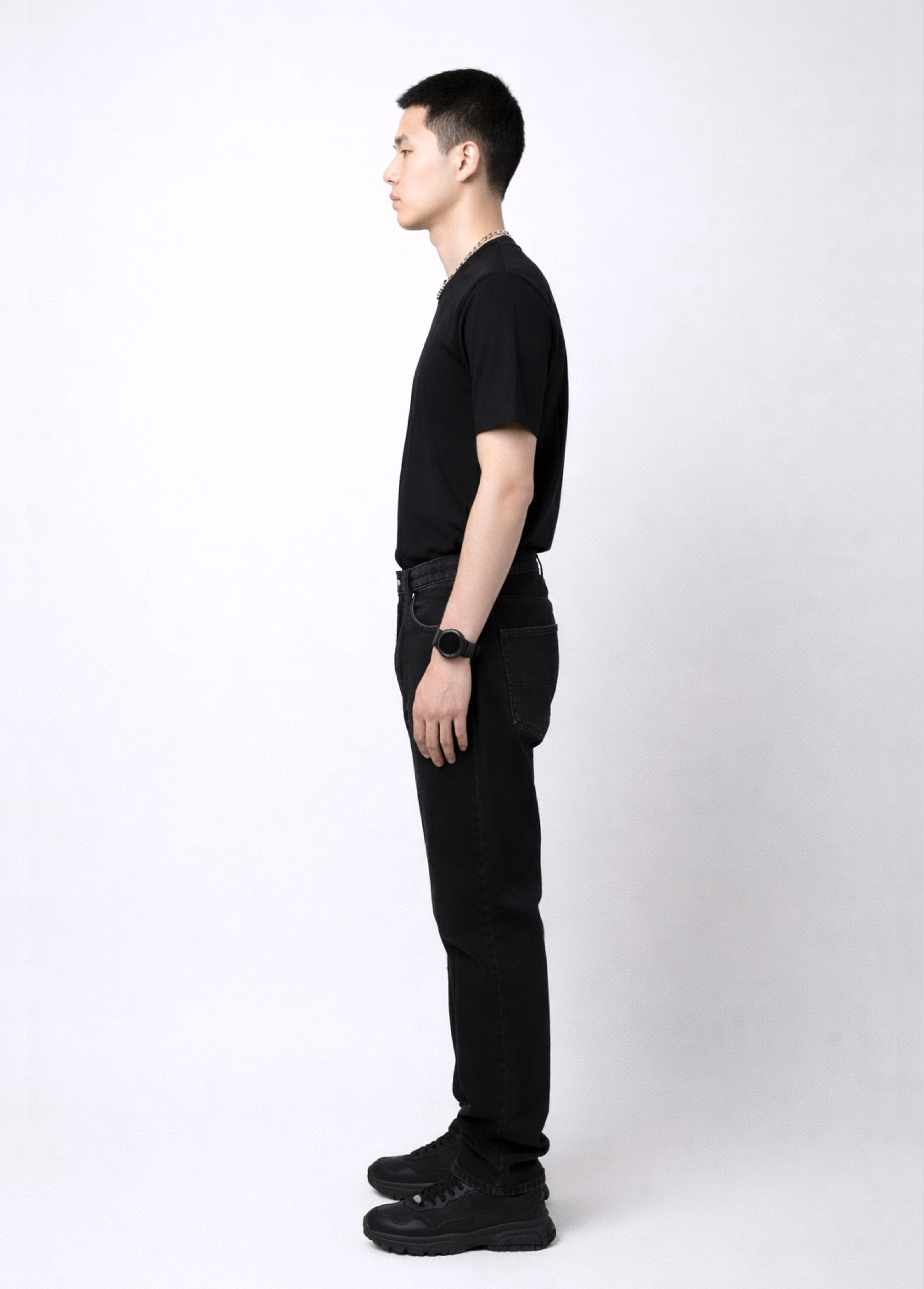 Man wearing an essential Northwind black t-shirt with minimalist Northwind embroidered wolf logo on the back, Dr. Martens boots, Carhartt black pants