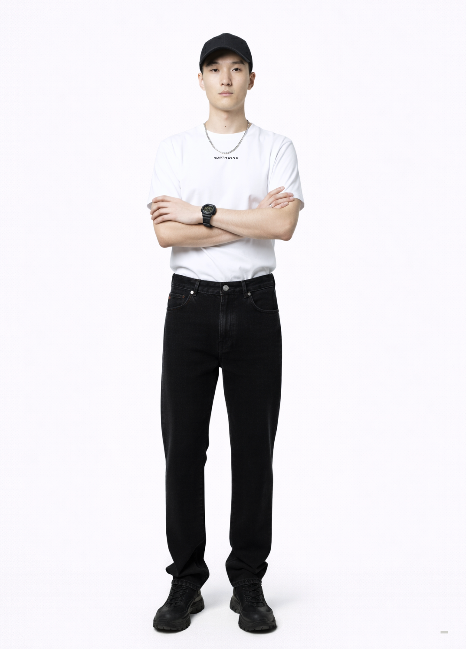 Man wearing an essential Northwind white t-shirt with minimalist Northwind embroidered logo on the chest, Dr. Martens boots, Carhartt black pants, black Rolex watch