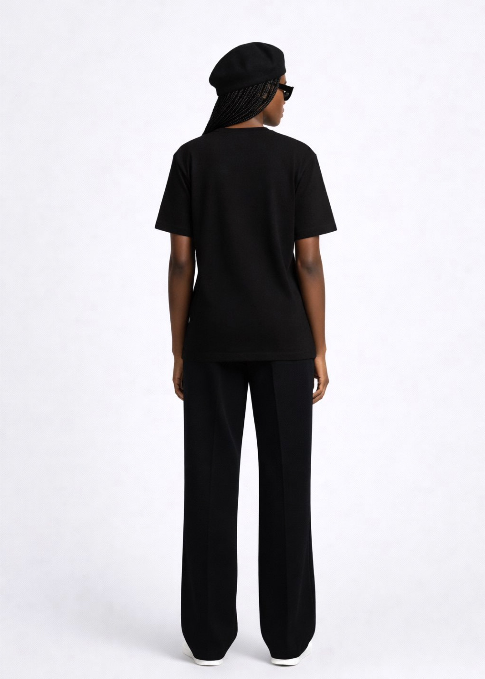 Black woman wearing a black essential Northwind t-shirt with embroidered logo on the chest, Gucci sunglasses, white Adidas Originals and black beret. 