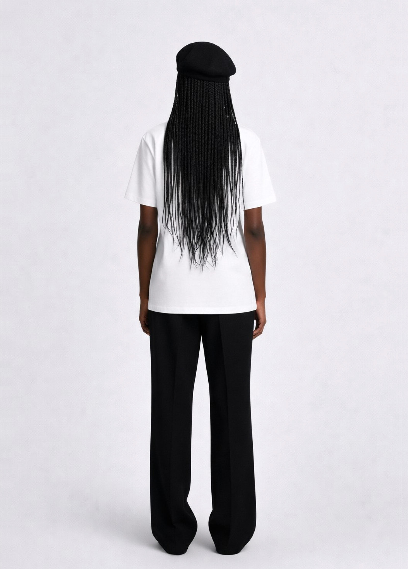 Black woman wearing a white essential Northwind t-shirt with embroidered logo on the chest, and black beret