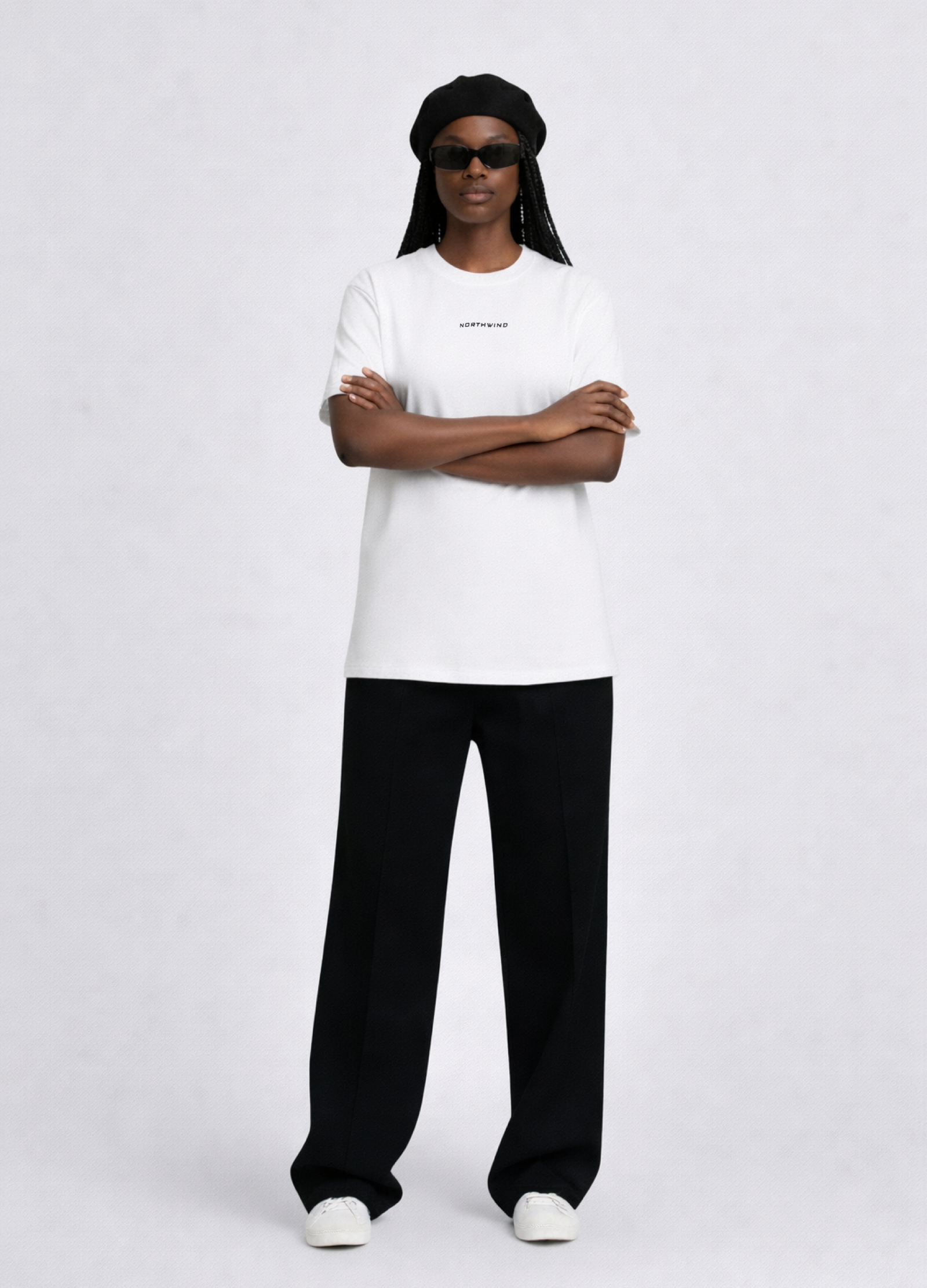 Black woman wearing a white essential Northwind t-shirt with embroidered logo, Gucci sunglasses, black beret and black pants