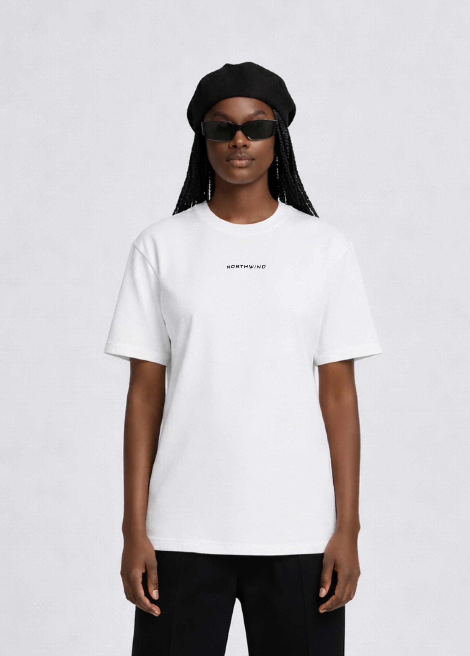 Black woman wearing a white essential Northwind t-shirt with embroidered logo on the chest, Gucci sunglasses and black beret