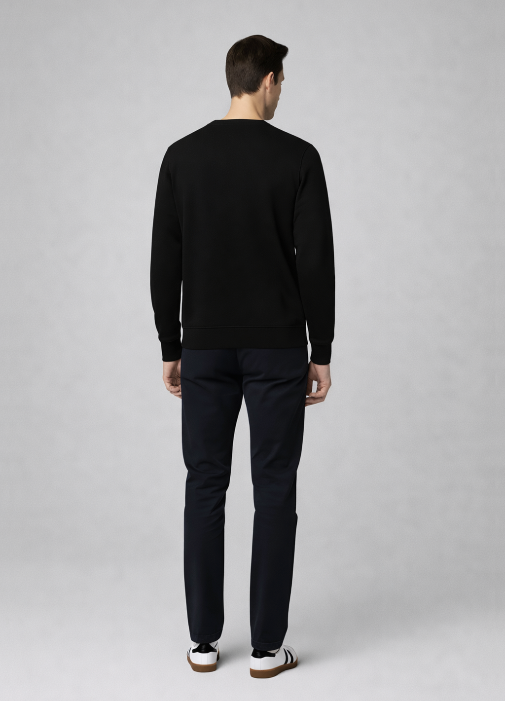 Man wearing a black Northwind sweater and pants standing against a gray background