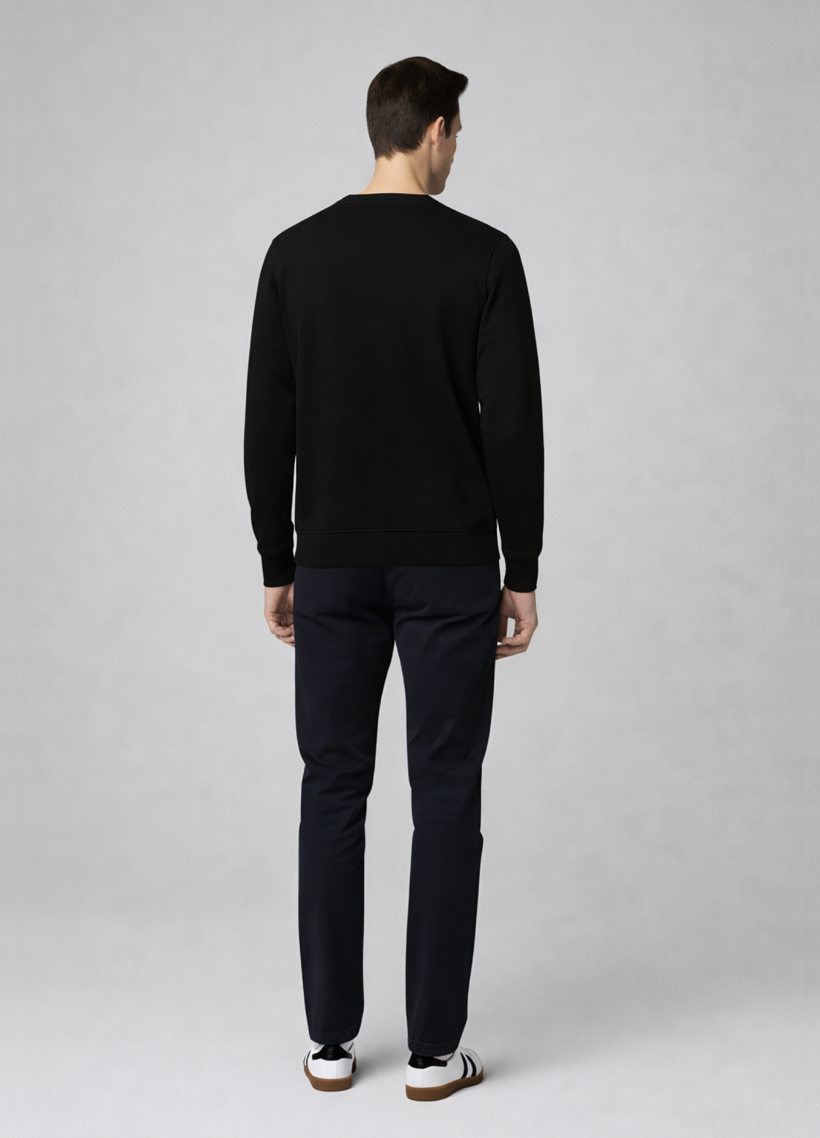 Man wearing a black Northwind sweater and pants standing against a gray background