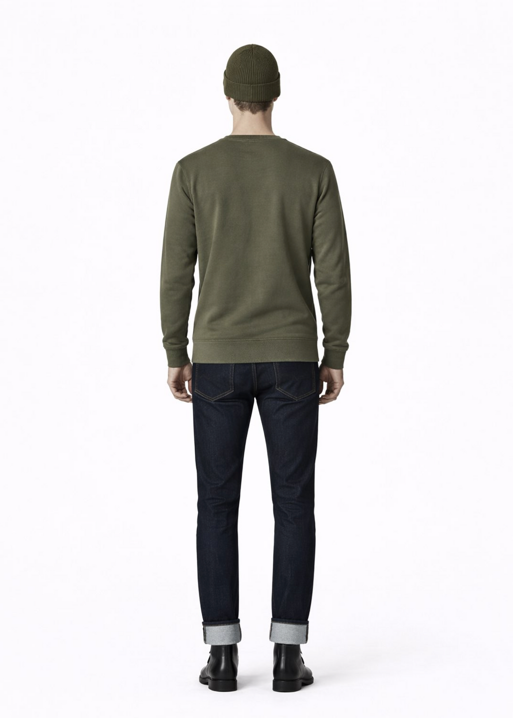 Person wearing a green Northwind sweater and black pants on a gray background