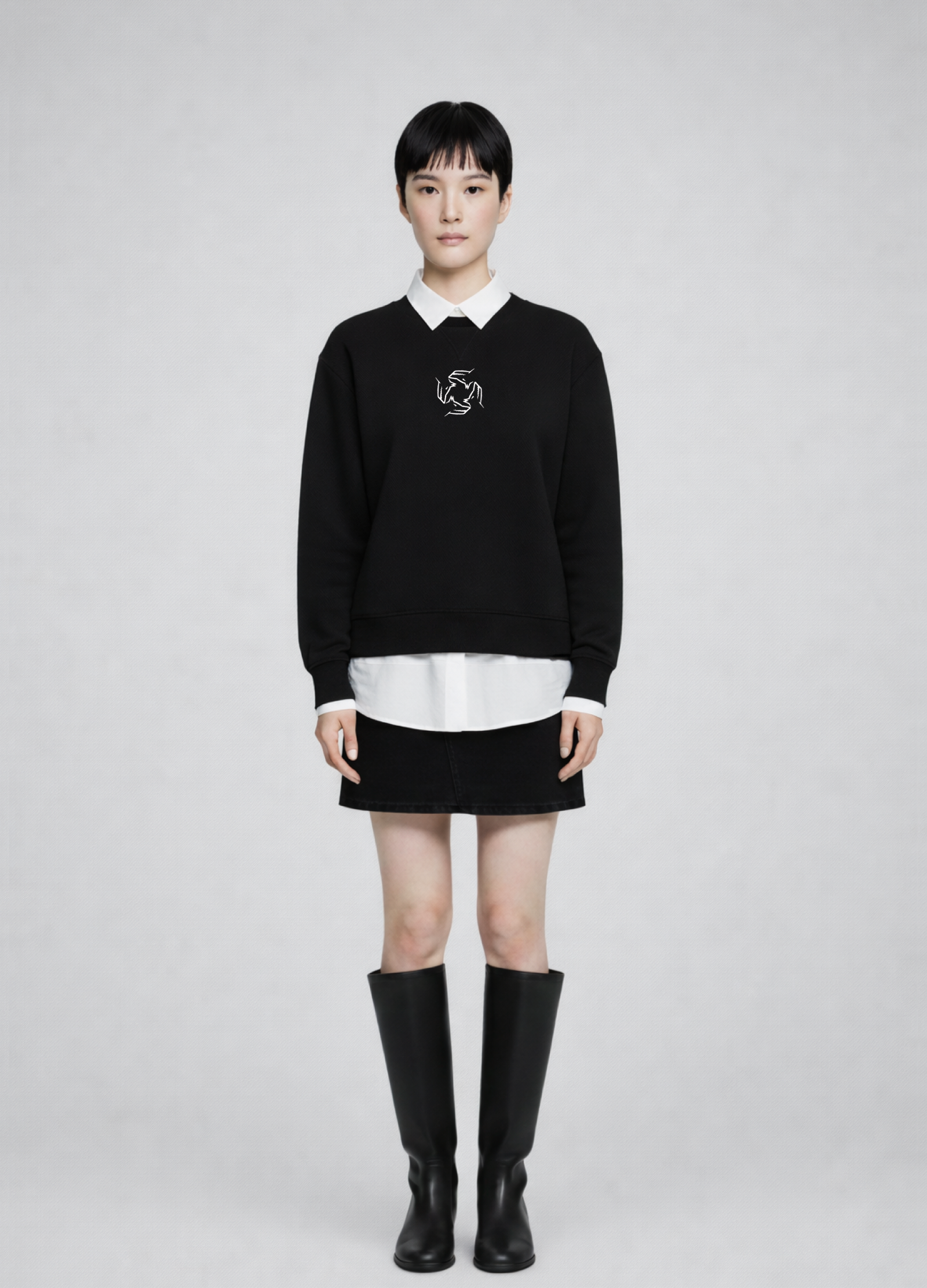 Woman wearing a black Northwind storm of wolves sweatshirt with a white collar, white shirt, black skirt, and black knee-high boots on a gray background