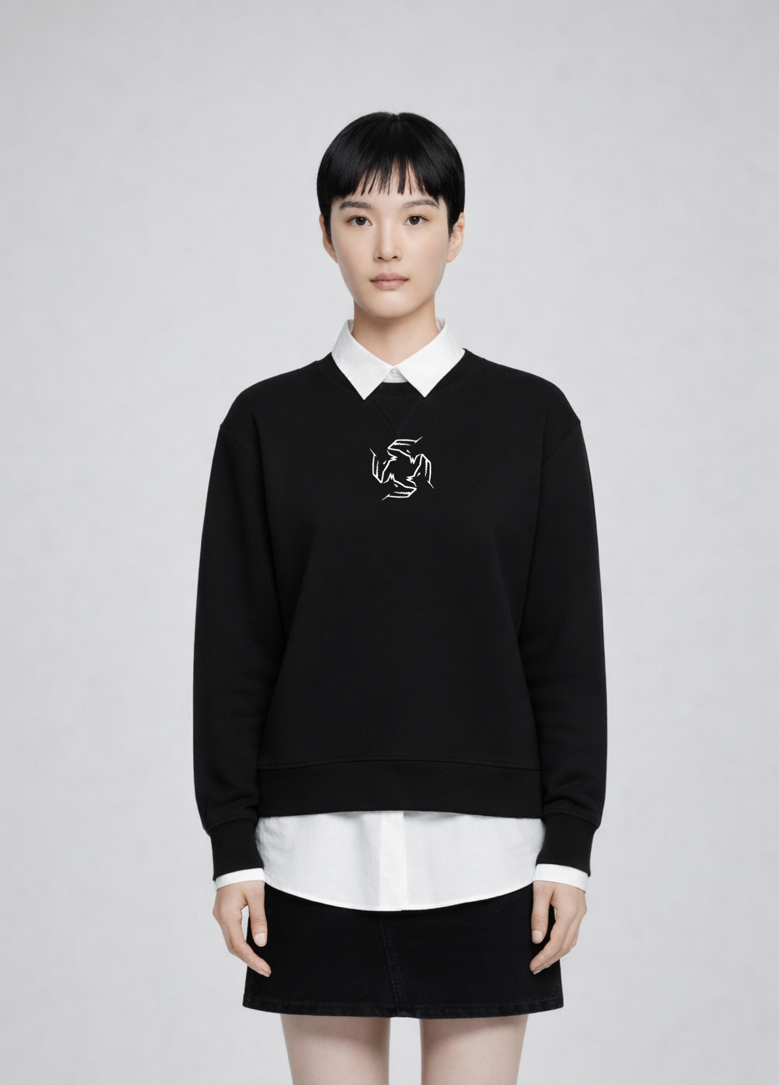 Woman wearing a black Northwind Storm of Wolves sweatshirt with a white collar and logo, standing against a plain background