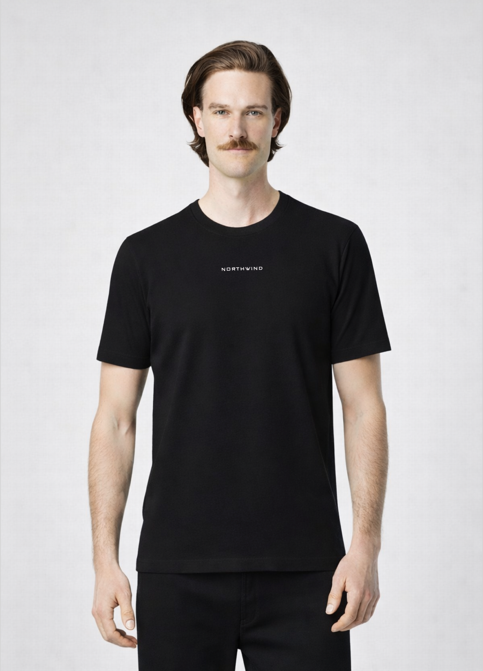 Man wearing a black Northwind storm of wolves t-shirt with embroidered Northwind logo on the chest