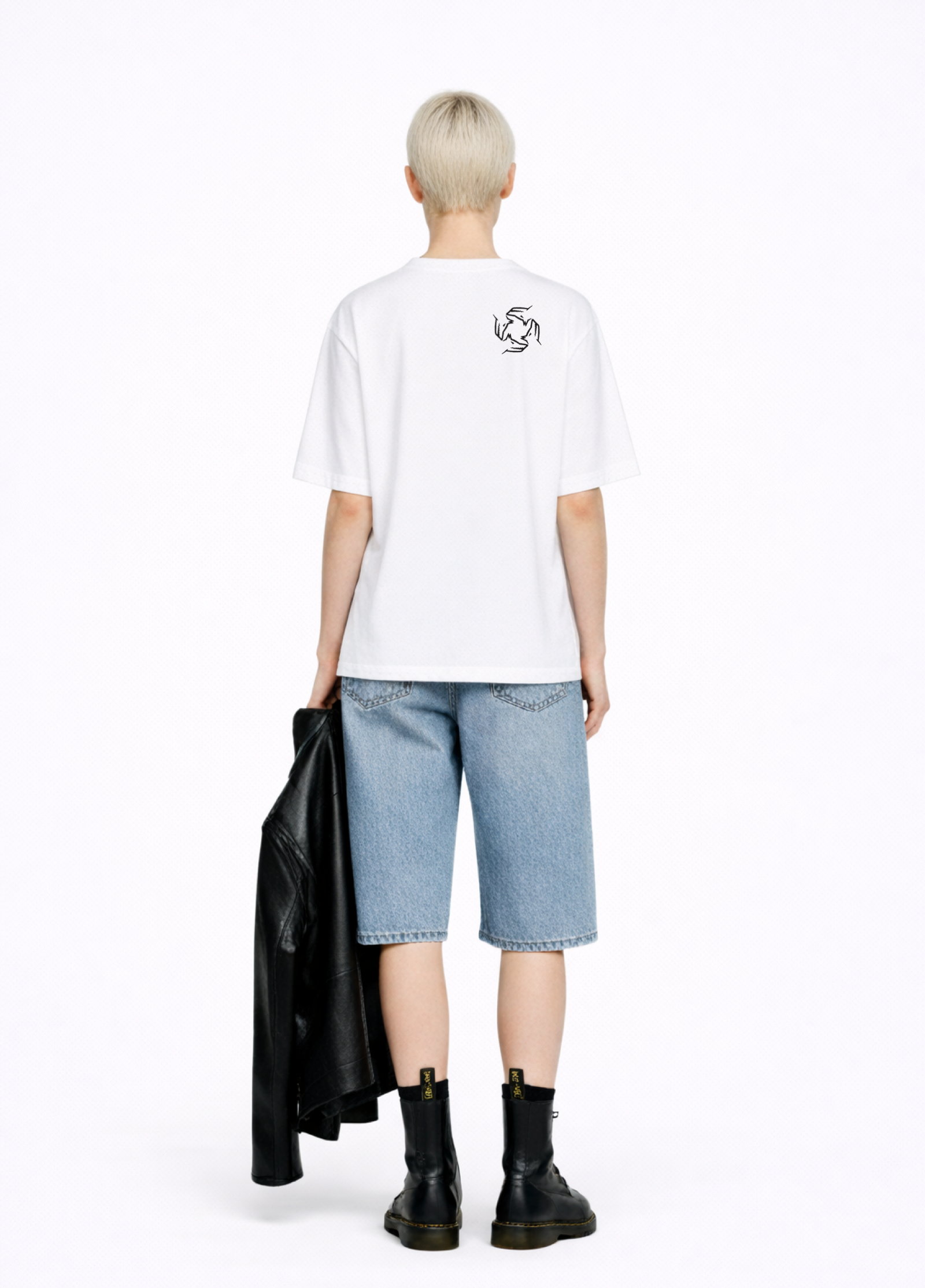 Blond, short hair girl wearing a white Northwind casual storm of wolves t-shirt with Northwind storm of wolves  embroidered logo on the back, blue denim Carhartt oversized shorts, black belt, and black Dr. Martens boots on a white background