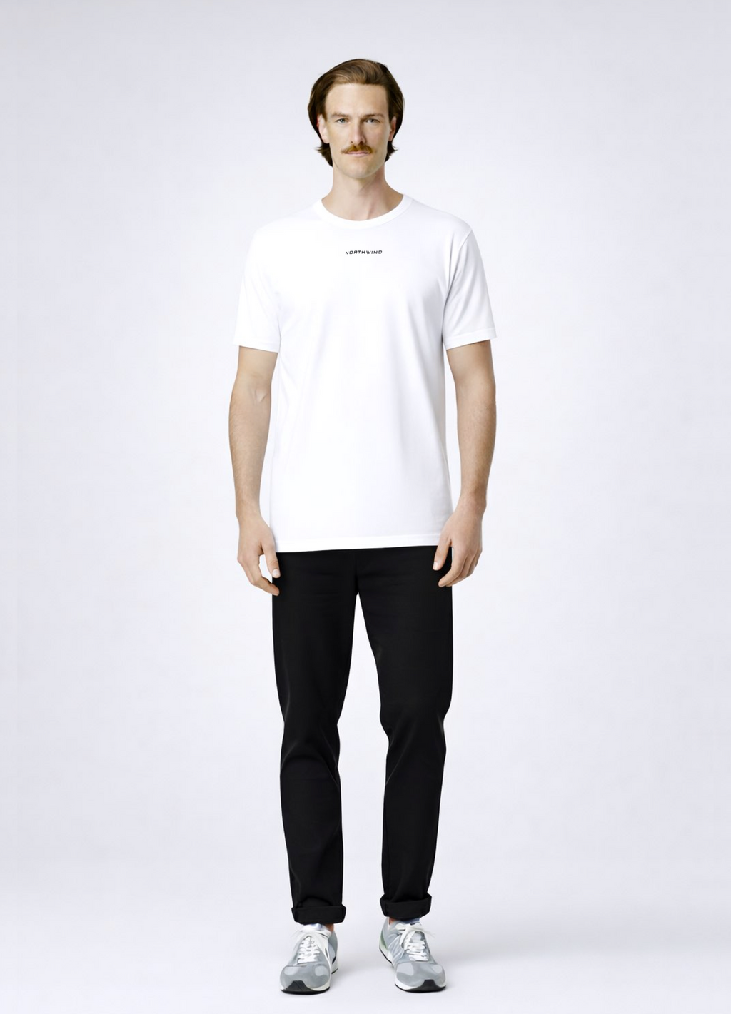 Man wearing a white Northwind storm of wolves t-shirt with embroidered Northwind storm of wolves logo on the back, gray New Balance shoes