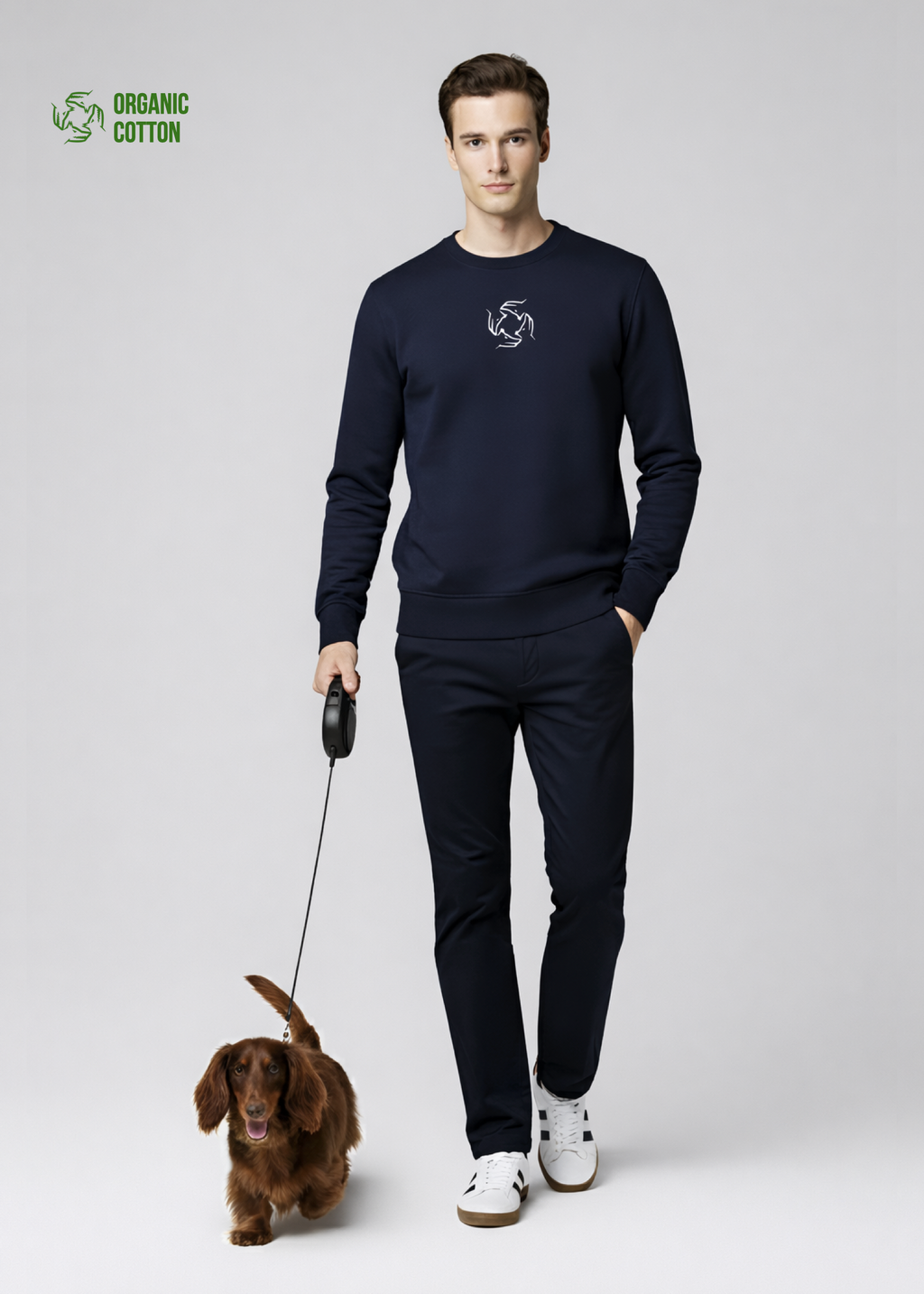 Man wearing a french navy Northwind sweatshirt with Northwind wolf storm embroidered logo, walking with a longhaired dachshund 