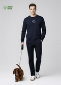Man wearing a french navy Northwind sweatshirt with Northwind wolf storm embroidered logo, walking with a longhaired dachshund 