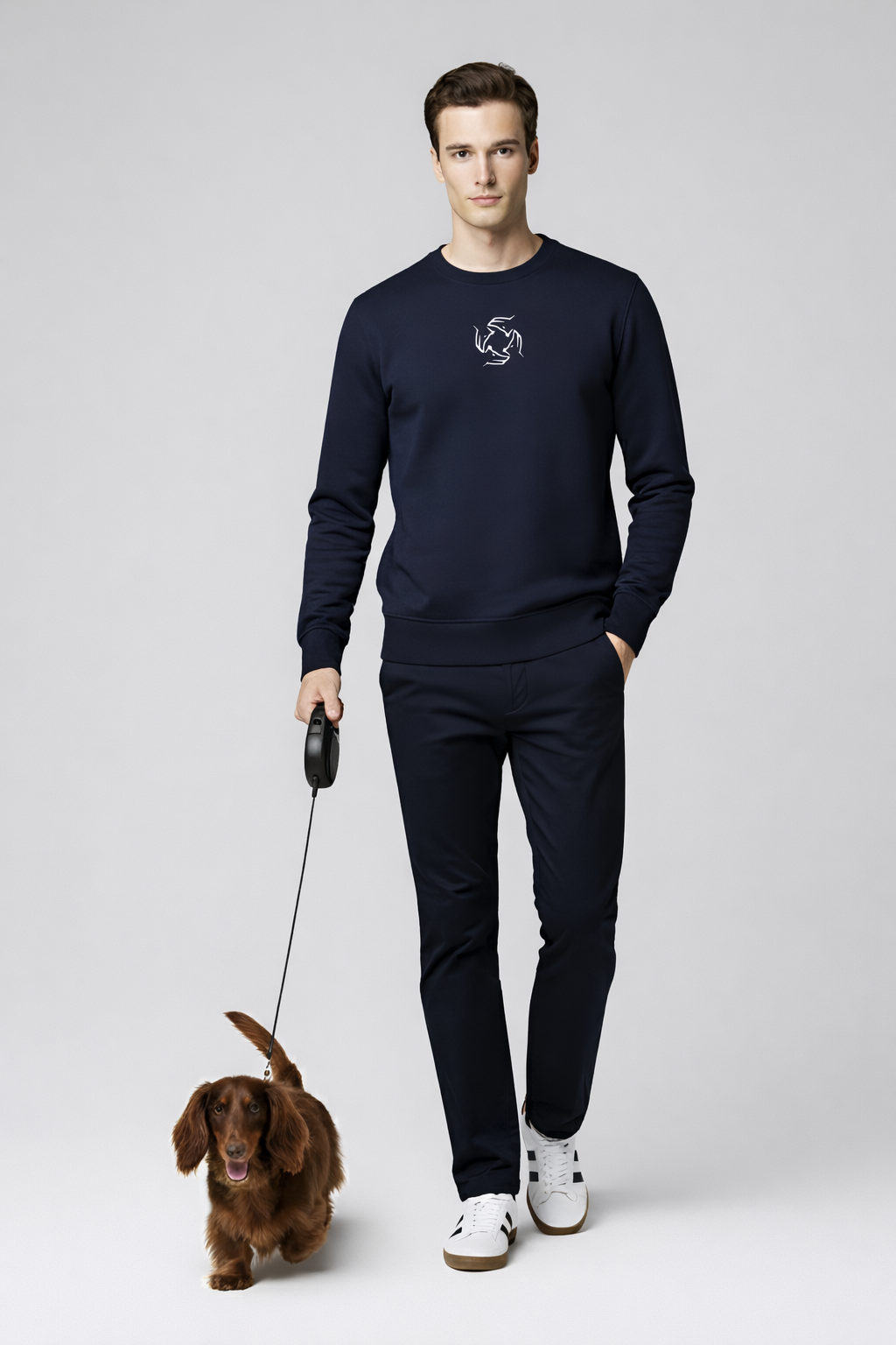 Man wearing a french navy Northwind sweatshirt with Northwind wolf storm embroidered logo, walking with a longhaired dachshund 