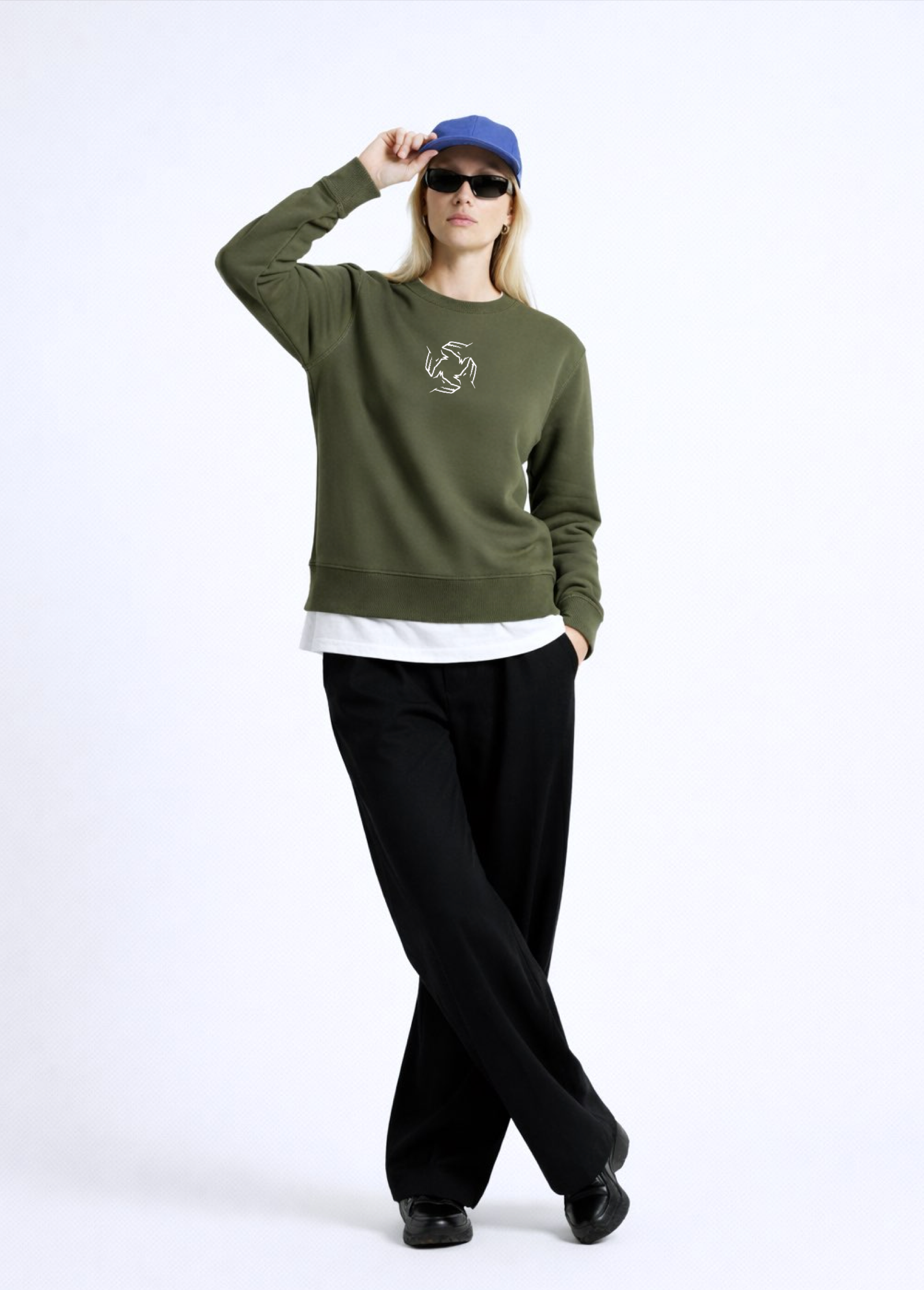 Person wearing an olive khaki green Northwind sweatshirt with Northwind storm of wolves embroidered logo on the chest, black pants, and a blue cap on a white background