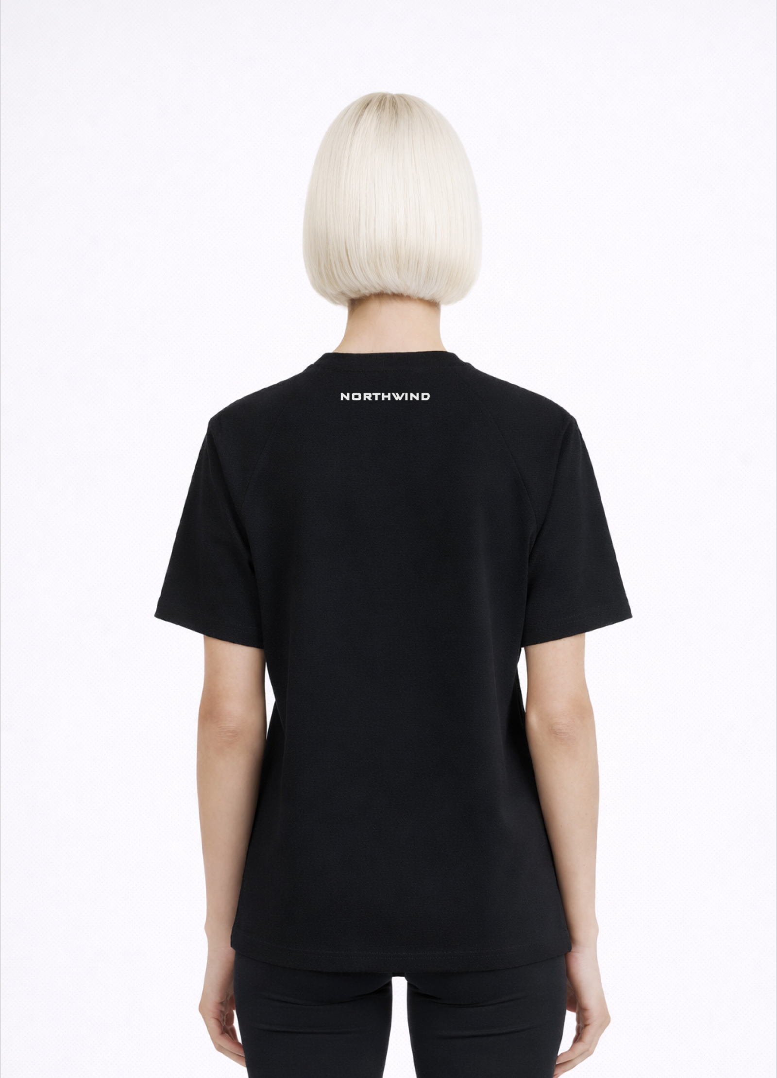 Woman wearing a black Northwind activewear t-shirt with 'NORTHWIND' branding on the back, standing against a white background.